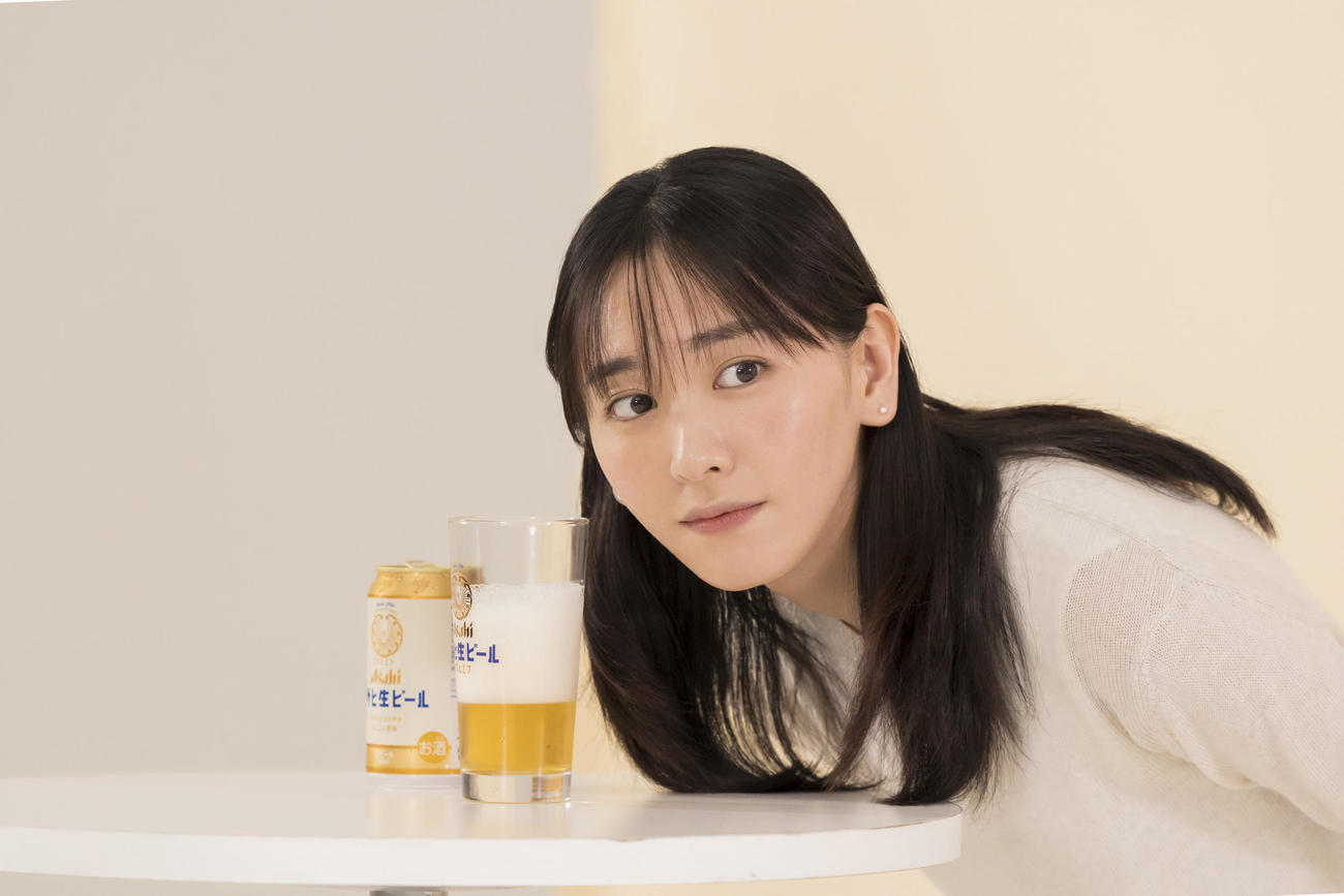 「アサヒ生ビール」新テレビCMの撮影中、ビールを注いだグラスに耳を近づけて、泡の音に耳を澄ませる新垣結衣