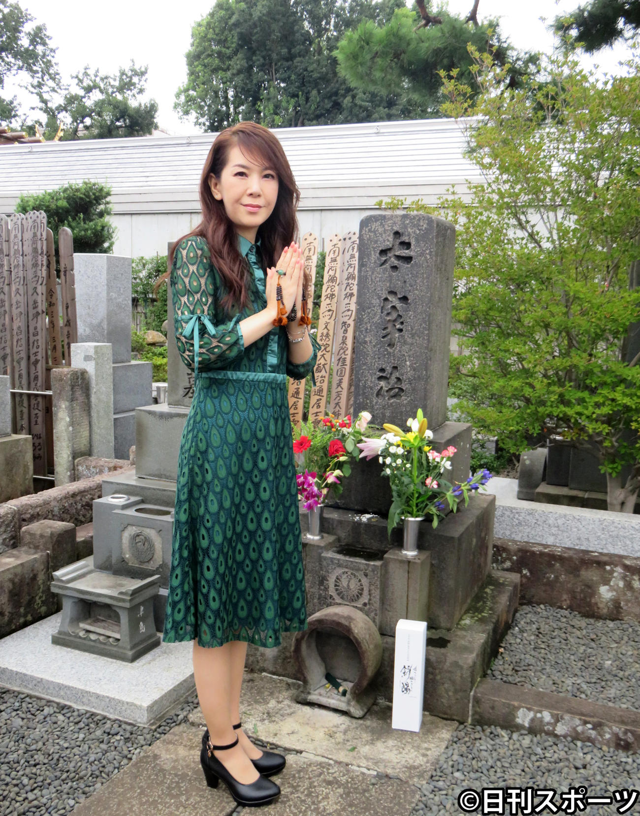 作家太宰治の墓に純米酒「斜陽」を供えて、新曲「少しは私に愛を下さい」のヒット祈願をした白石恭子（撮影・小谷野俊哉）