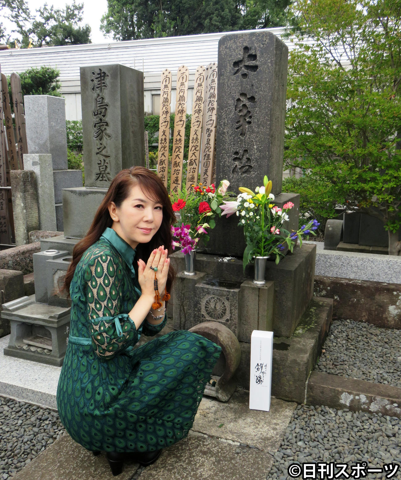 太宰治の墓の前で手を合わせる白石恭子（撮影・小谷野俊哉）