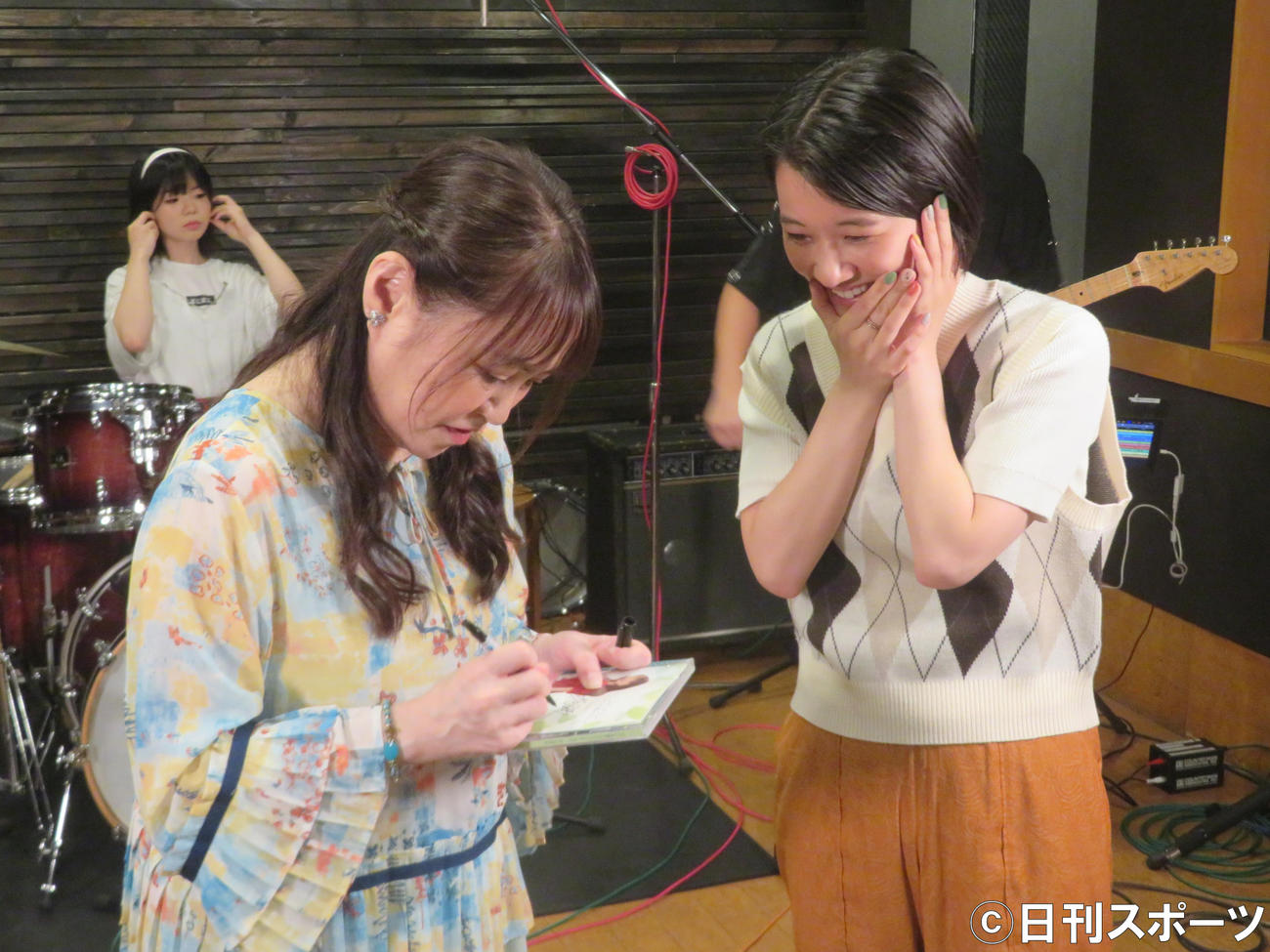 井上あずみ（左）からCDにサインをもらい、笑みがこぼれる太田唯