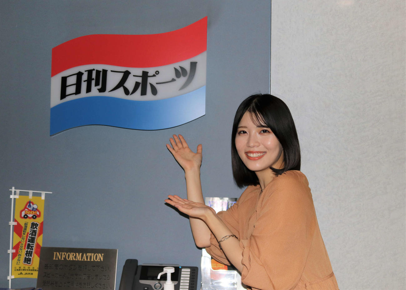 日刊スポーツのロゴの前でポーズをとる羽柴なつみ（撮影・小林憲治）