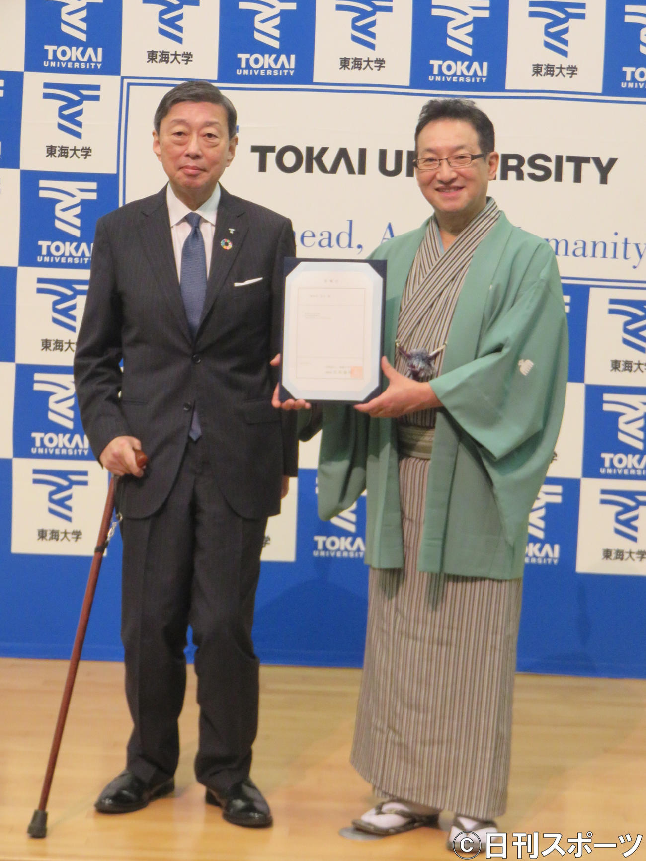 山田清志東海大学長（左）から渡された東海大客員教授の委嘱状を手にする春風亭昇太