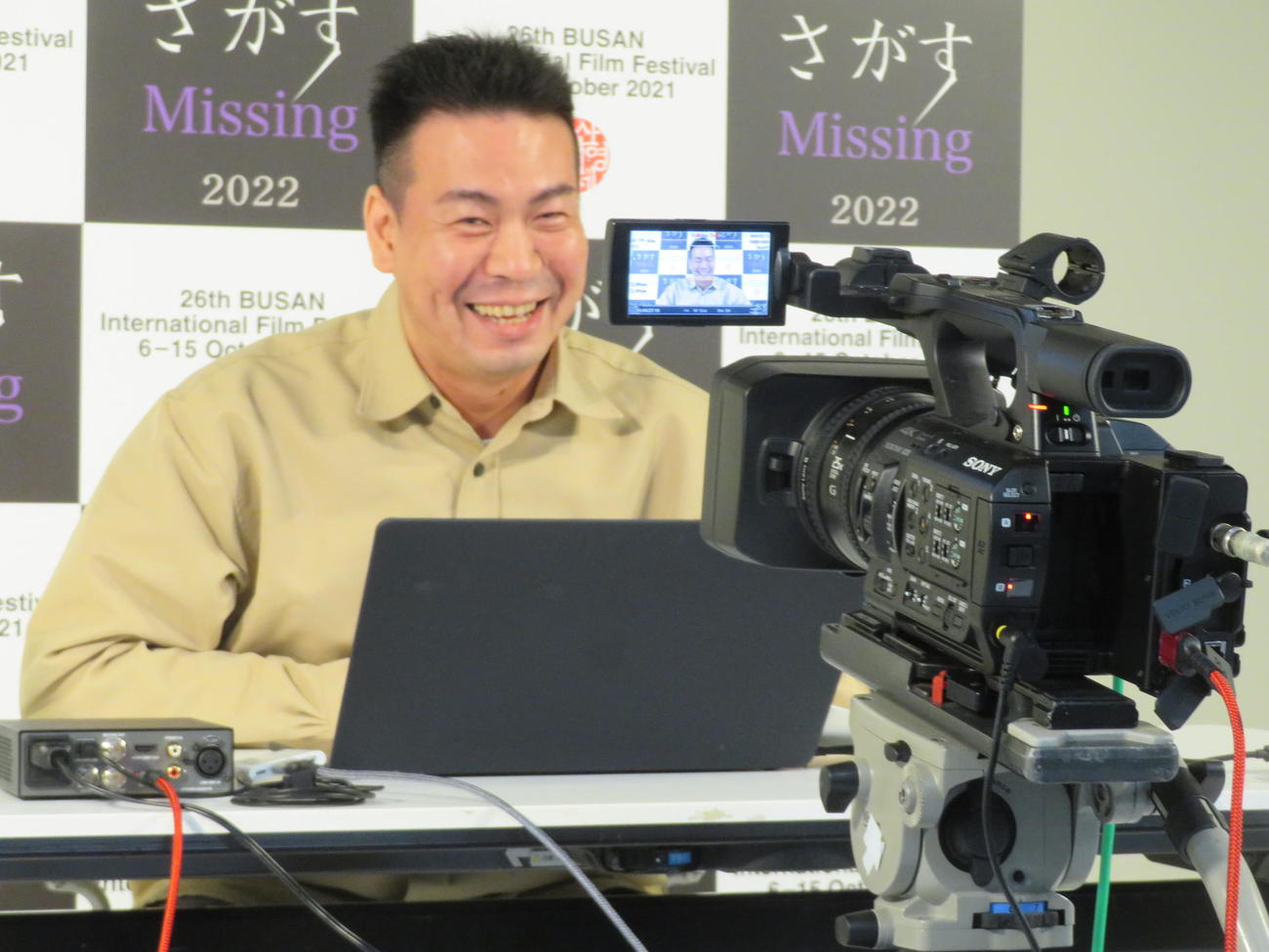 釜山映画祭ワールドプレミアイベントに都内からリモートで参加し、笑みを浮かべる片山慎三監督（撮影・村上幸将）