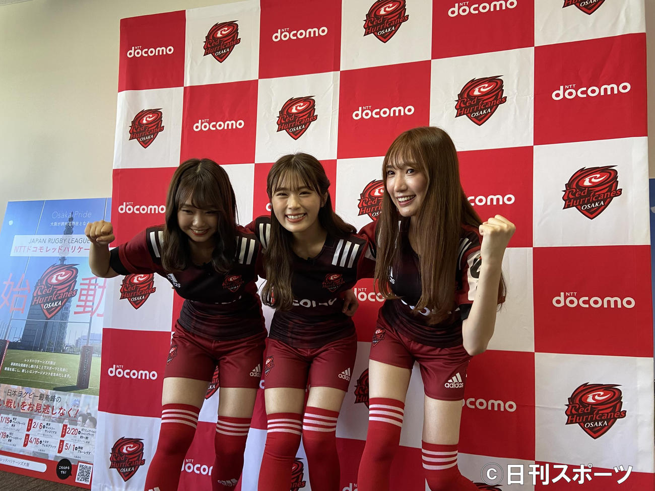NTTドコモレッドハリケーンズ大阪の公式アンバサダーに就任したNMB48の左から加藤夕夏、渋谷凪咲、原かれんはスクラムを組む（撮影・松本航）