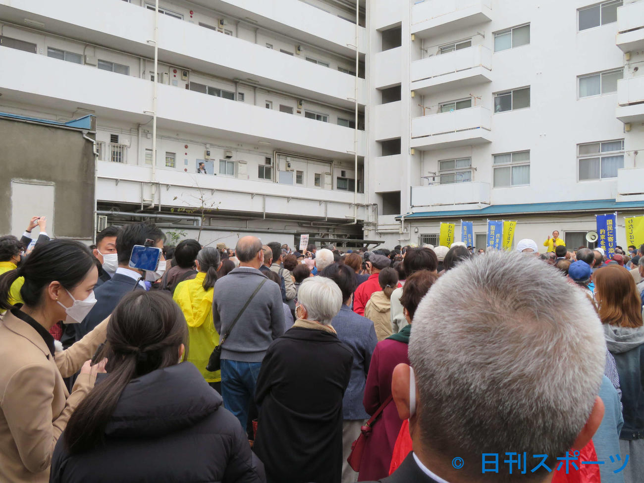 菅義偉前首相が横浜市営地下鉄弘明寺駅前に場所を移して行った南区出陣式をスマートフォンで撮影する小川彩佳アナウンサー（左）（撮影・村上幸将）