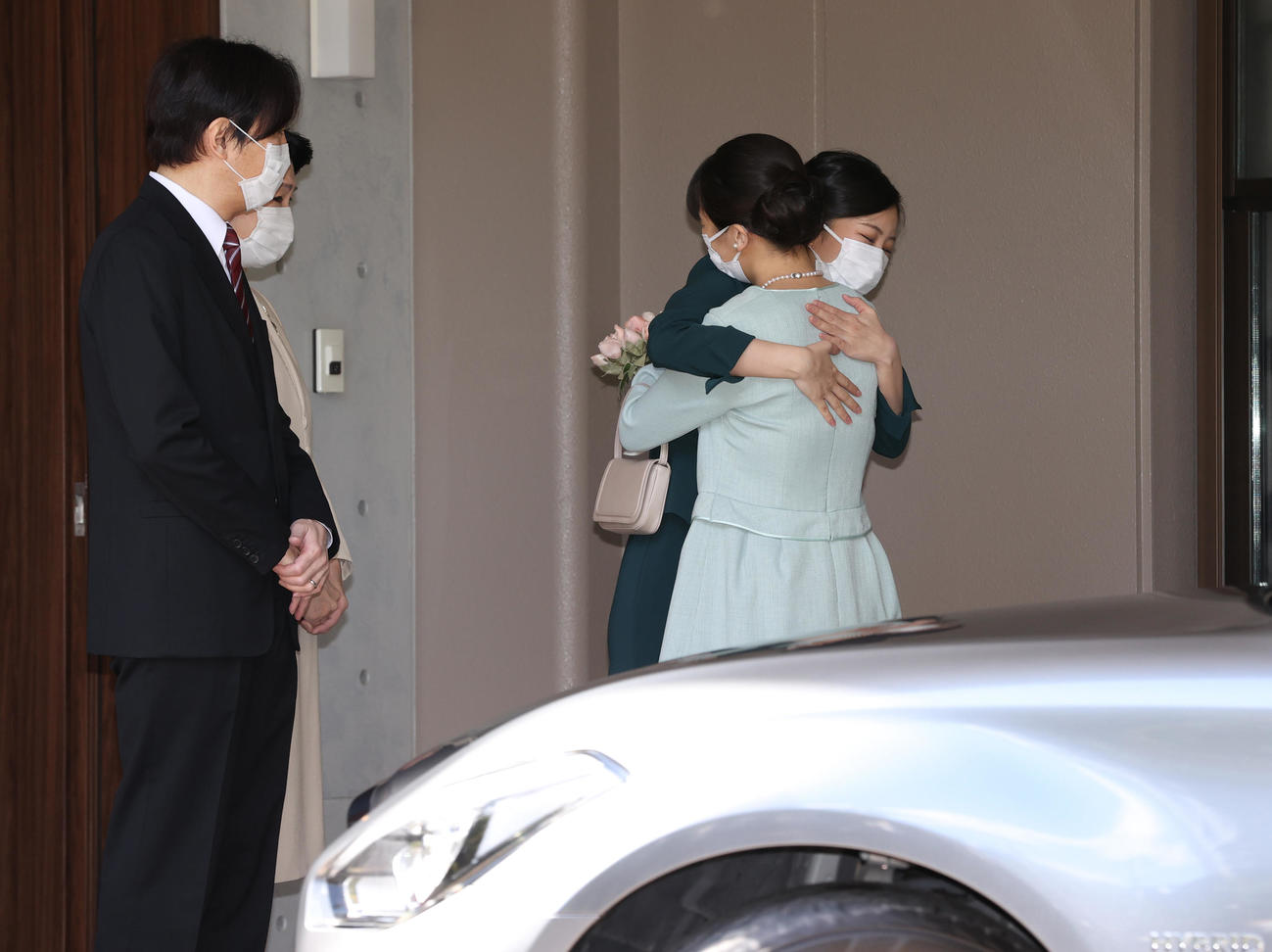 赤坂御用地にあるお住まいの宮邸を出発される秋篠宮ご夫妻の長女、眞子さま。秋篠宮ご夫妻が見送られるなか、次女の佳子さまと抱き合われた（代表撮影）