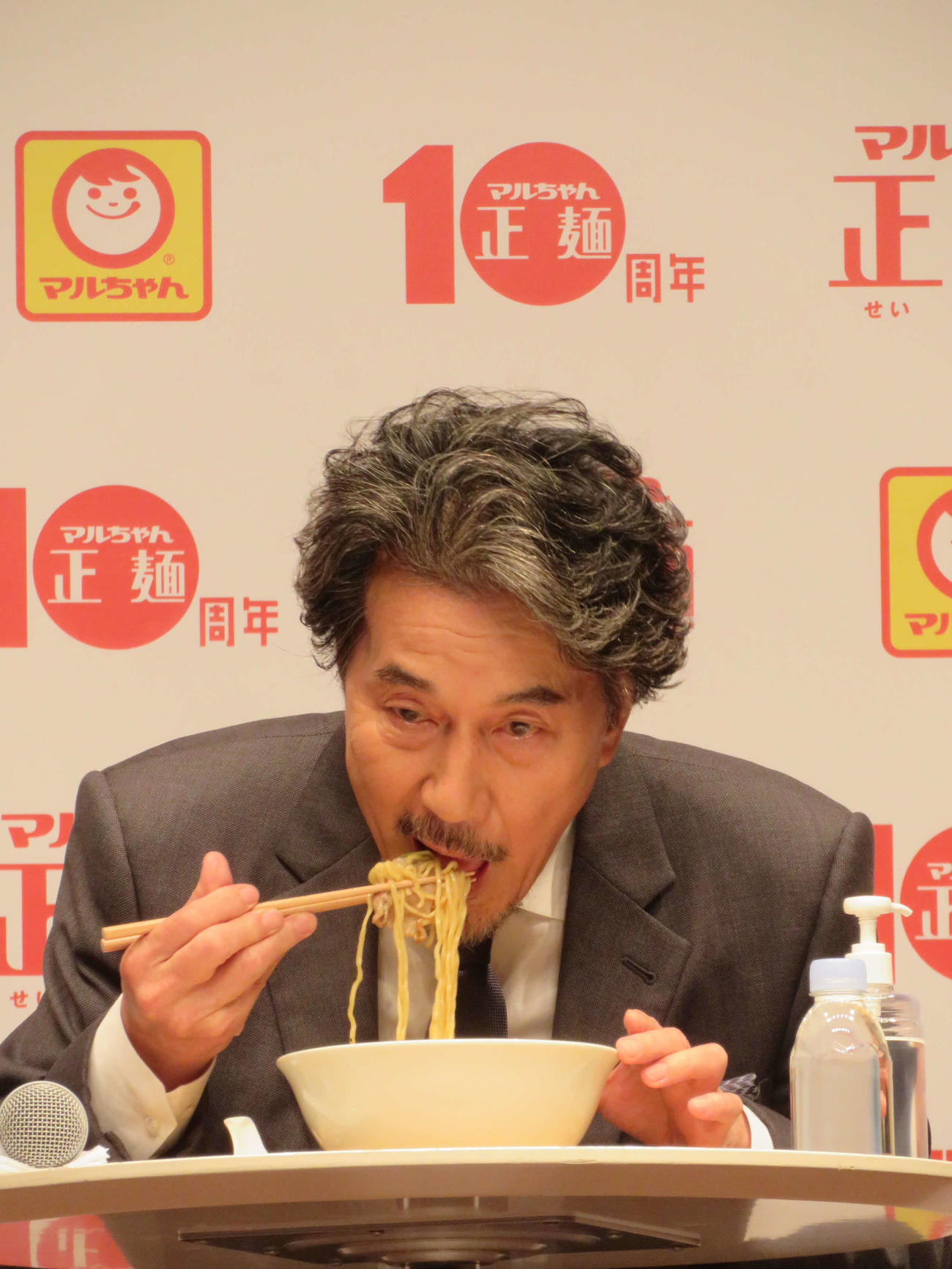 「マルちゃん正麺　10周年記念発表会」でガリバタ肉野菜正麺を実食する役所広司（2021年10月撮影）