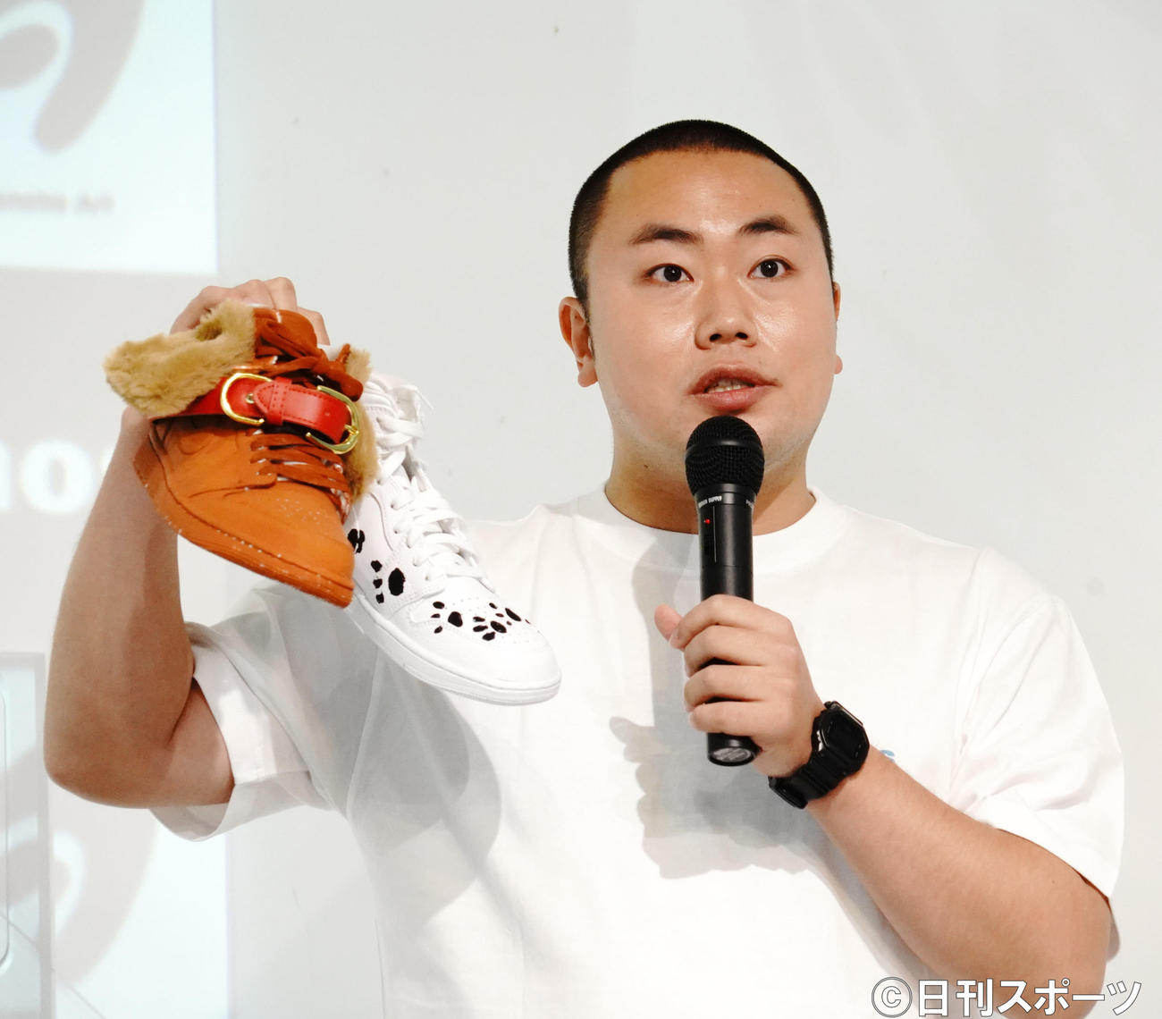 企画展「WatanabeArtmos」のキックオフイベントに出席し、デザインしたスニーカーを掲げるハナコ岡部大（撮影・佐藤成）