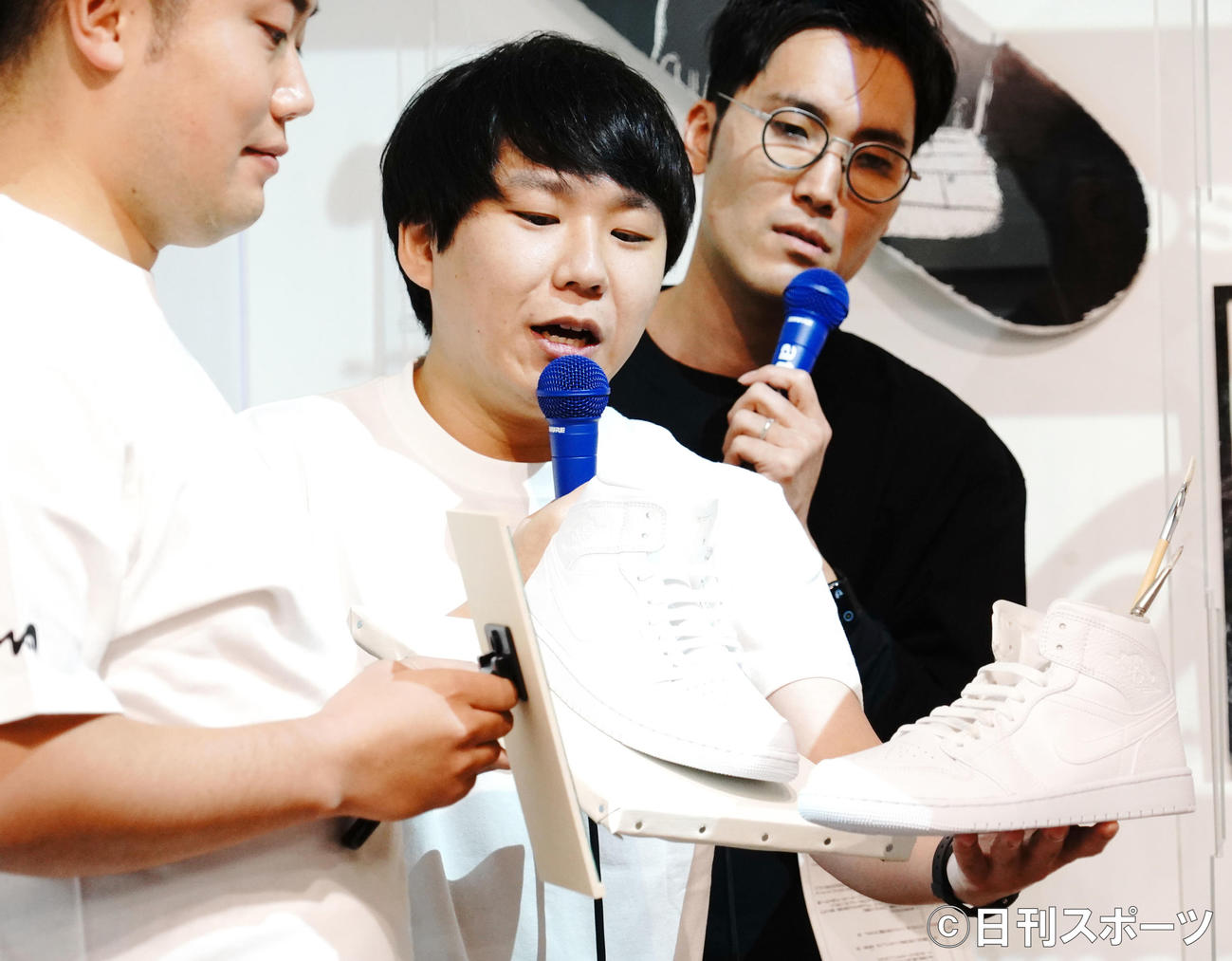 企画展「WatanabeArtmos」のキックオフイベントに出席し、ハナコ秋山寛貴（中）のデザインしたスニーカーをみる岡部大（左）と菊田竜大（右）（撮影・佐藤成）
