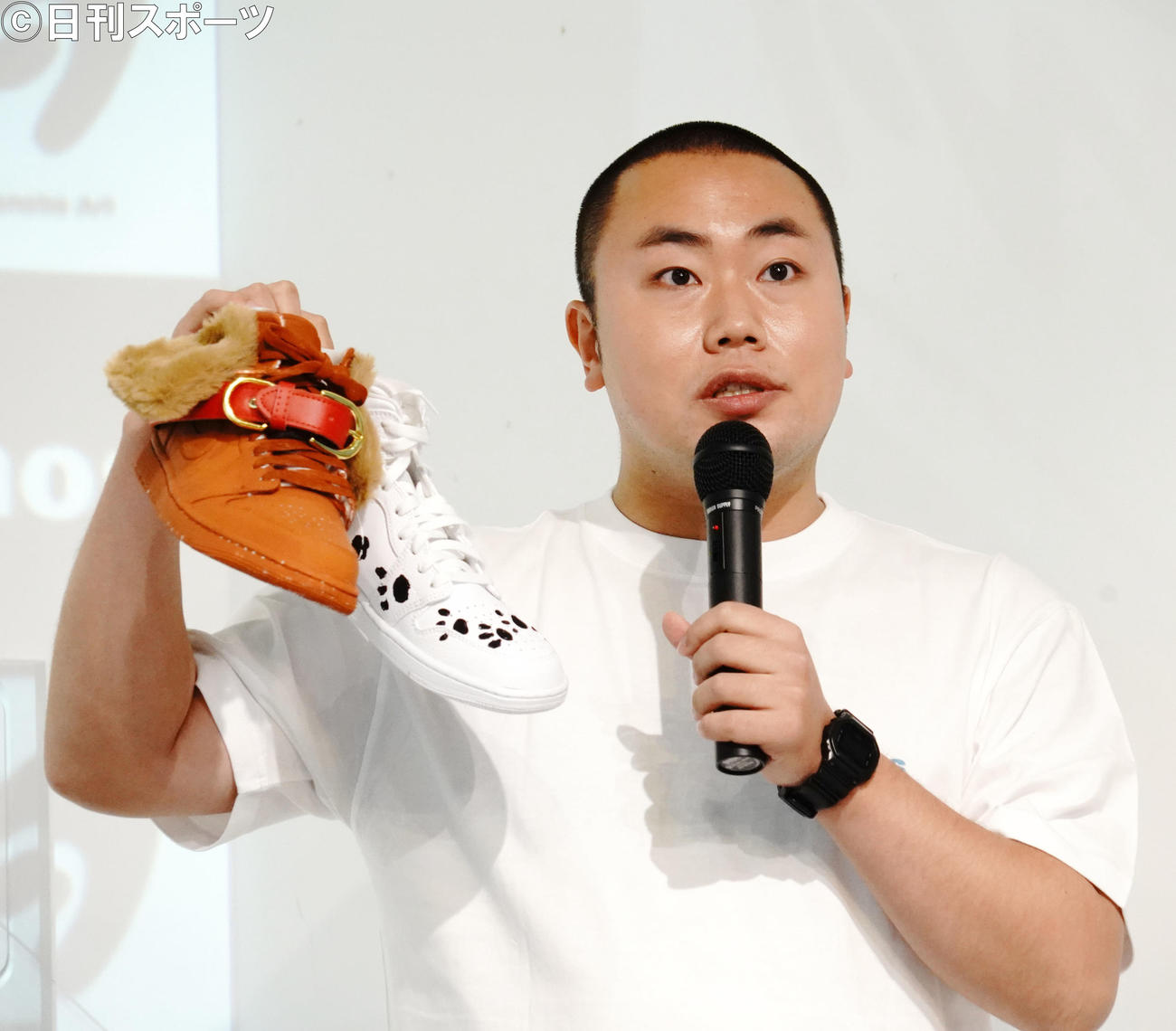 企画展「WatanabeArtmos」のキックオフイベントに出席し、デザインしたスニーカーを掲げるハナコ岡部大（撮影・佐藤成）