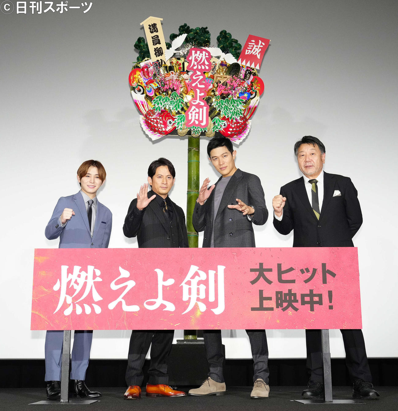 映画「燃えよ剣」公開御礼舞台あいさつで熊手を背に写真に納まる、左から山田涼介、岡田准一、鈴木亮平、原田眞人監督（撮影・江口和貴）