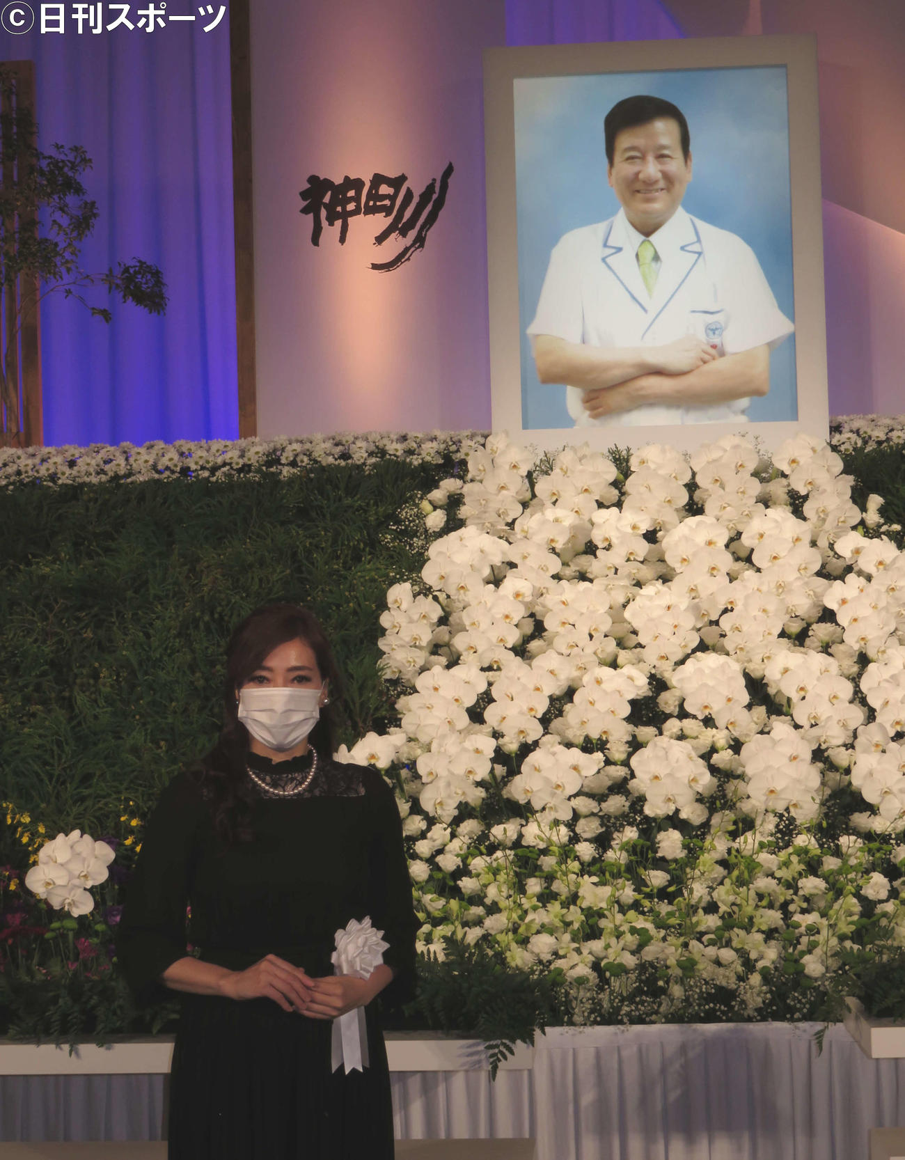 父の写真、祭壇の前に立つ長女の大竹可江さん（撮影・村上久美子）