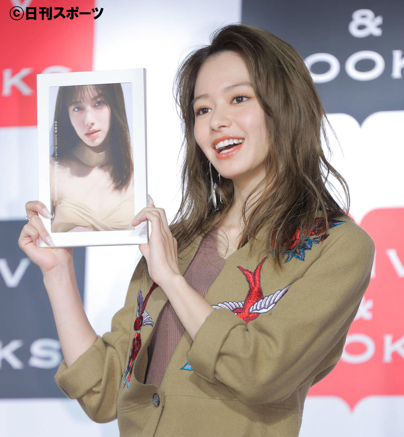 「山本舞香2022カレンダー」（コピーライト・KADOKAWA　撮影／土山大輔）を手に笑顔で写真に納まる山本舞香（撮影・河田真司）
