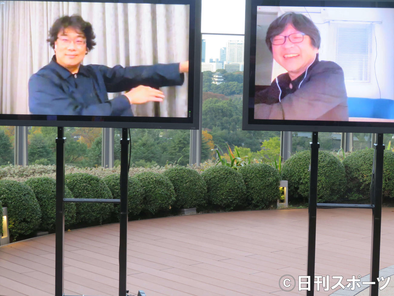 東京国際映画祭「トークシリーズ＠アジア交流ラウンジ」でオンラインで対談後、画面越しに抱き合うポーズをするポン・ジュノ監督（左）と細田守監督（撮影・村上幸将）
