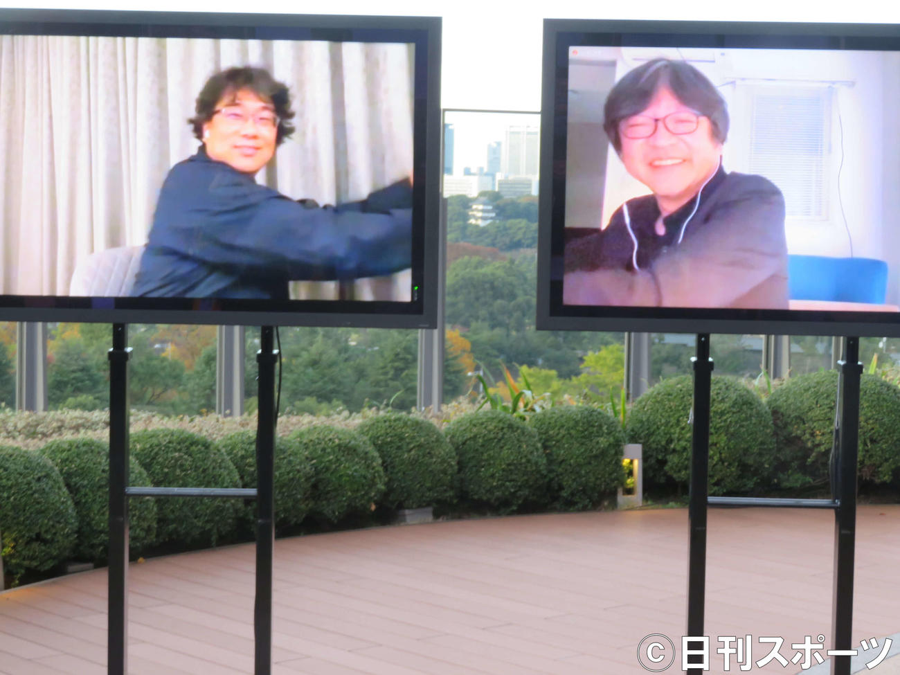 東京国際映画祭「トークシリーズ＠アジア交流ラウンジ」でオンラインで対談後、画面越しに抱き合うポーズをするポン・ジュノ監督（左）と細田守監督（撮影・村上幸将）