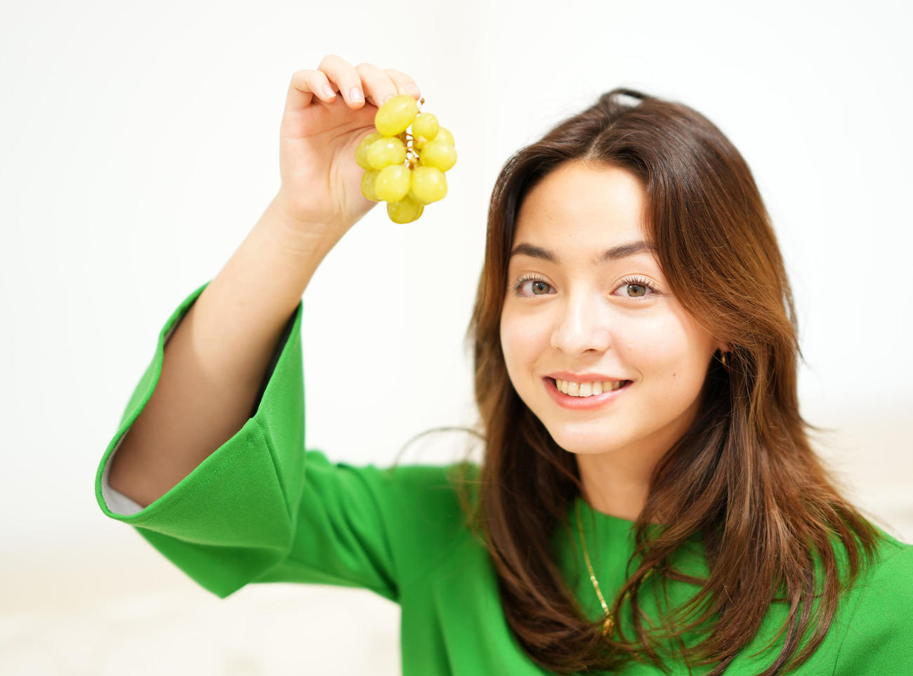 ぶどうを手に笑顔を見せる真理子（撮影・横山健太）