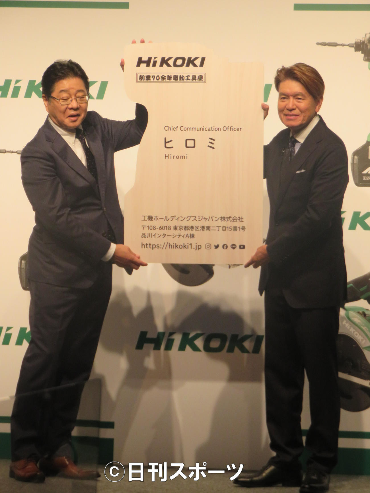 工機ホールディングスジャパンの吉田智彦社長（左）からCCOの特大名刺を手渡されるヒロミ