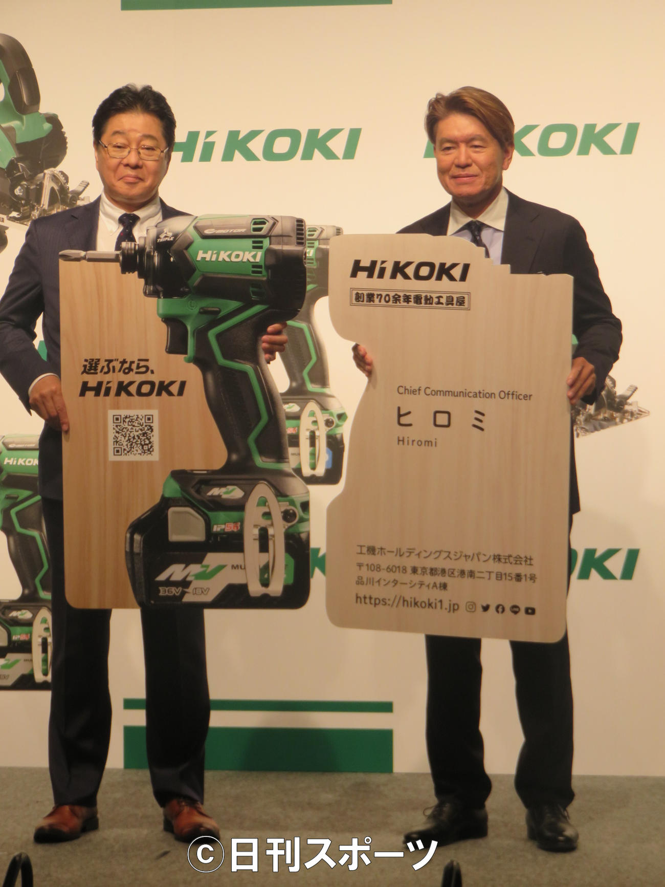 工機ホールディングスジャパンの吉田智彦社長（左）とCCOの特大名刺を持つヒロミ