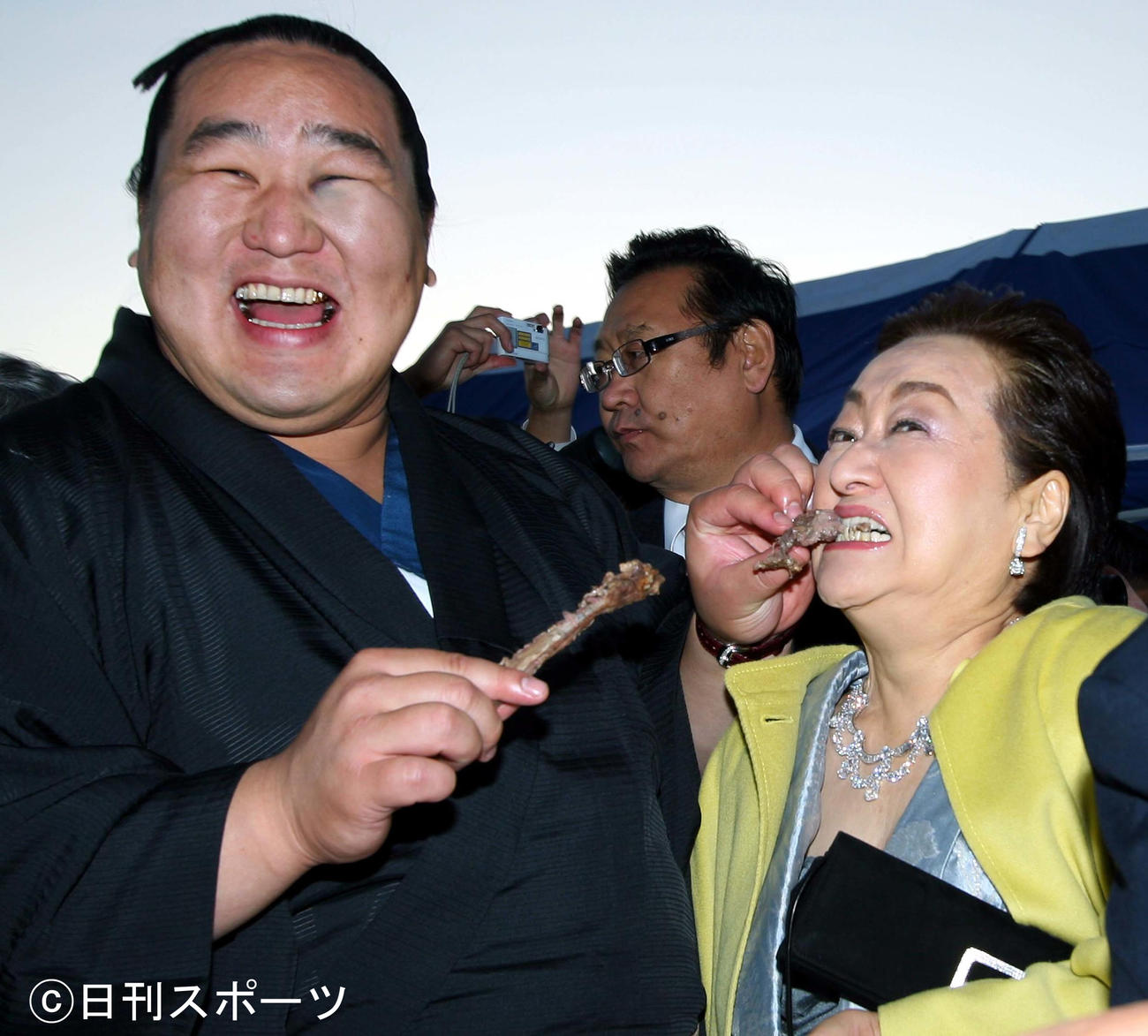 朝青龍（左）が差し出した羊肉にかぶりつく細木数子さん（08年8月）