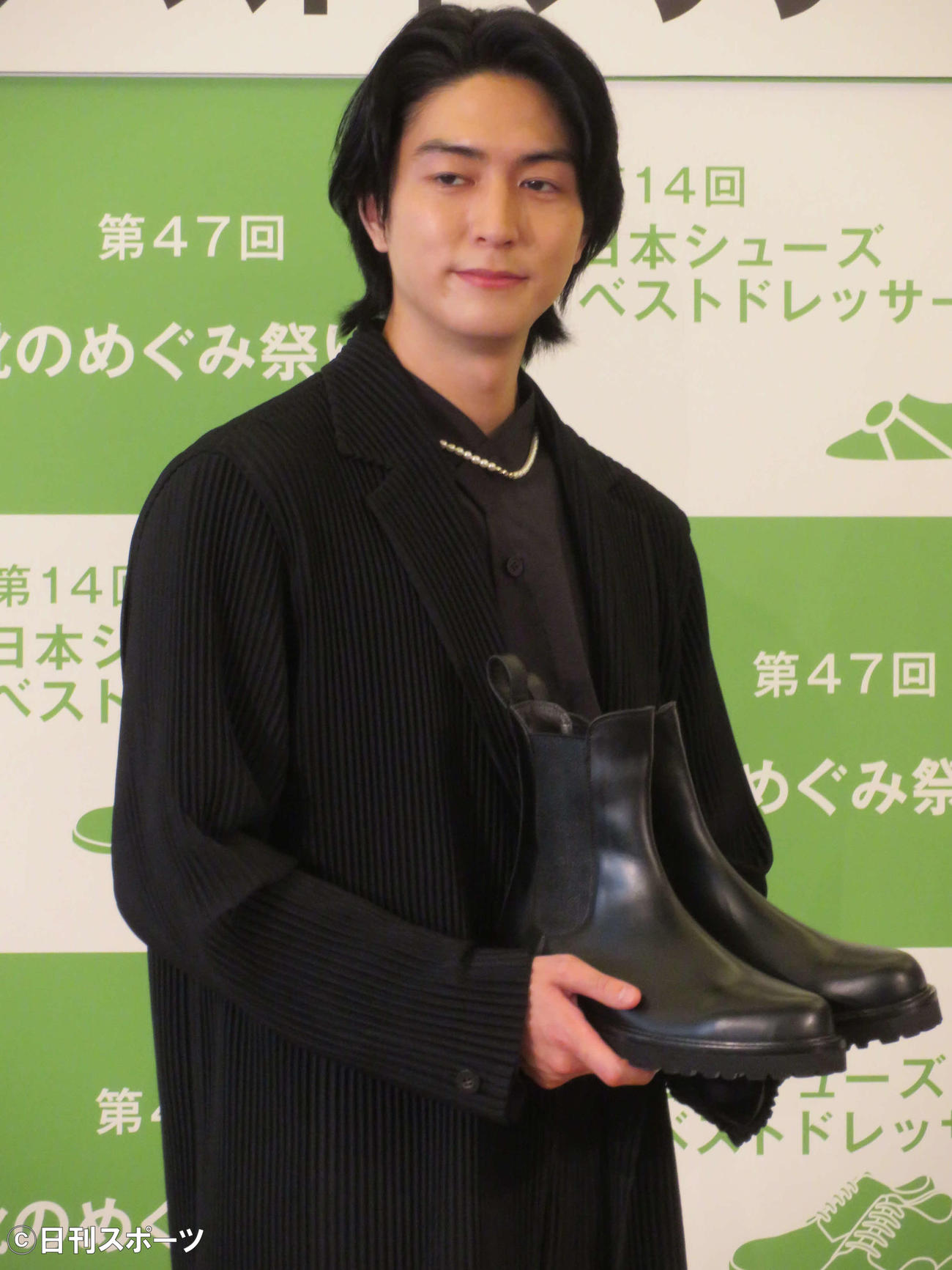 第14回日本シューズベストドレッサー賞記者発表会で、自身がデザインした靴を手に微笑を浮かべる稲葉友（撮影・村上幸将）