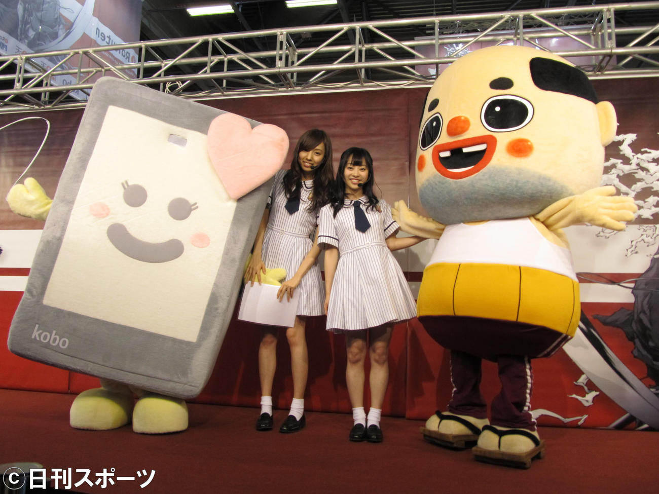 14年7月　楽天koboのゆるキャラ、コビー（左）にアドバイスを送ったちっちゃいおっさん（右）。中央左からは新内眞衣、伊藤寧々