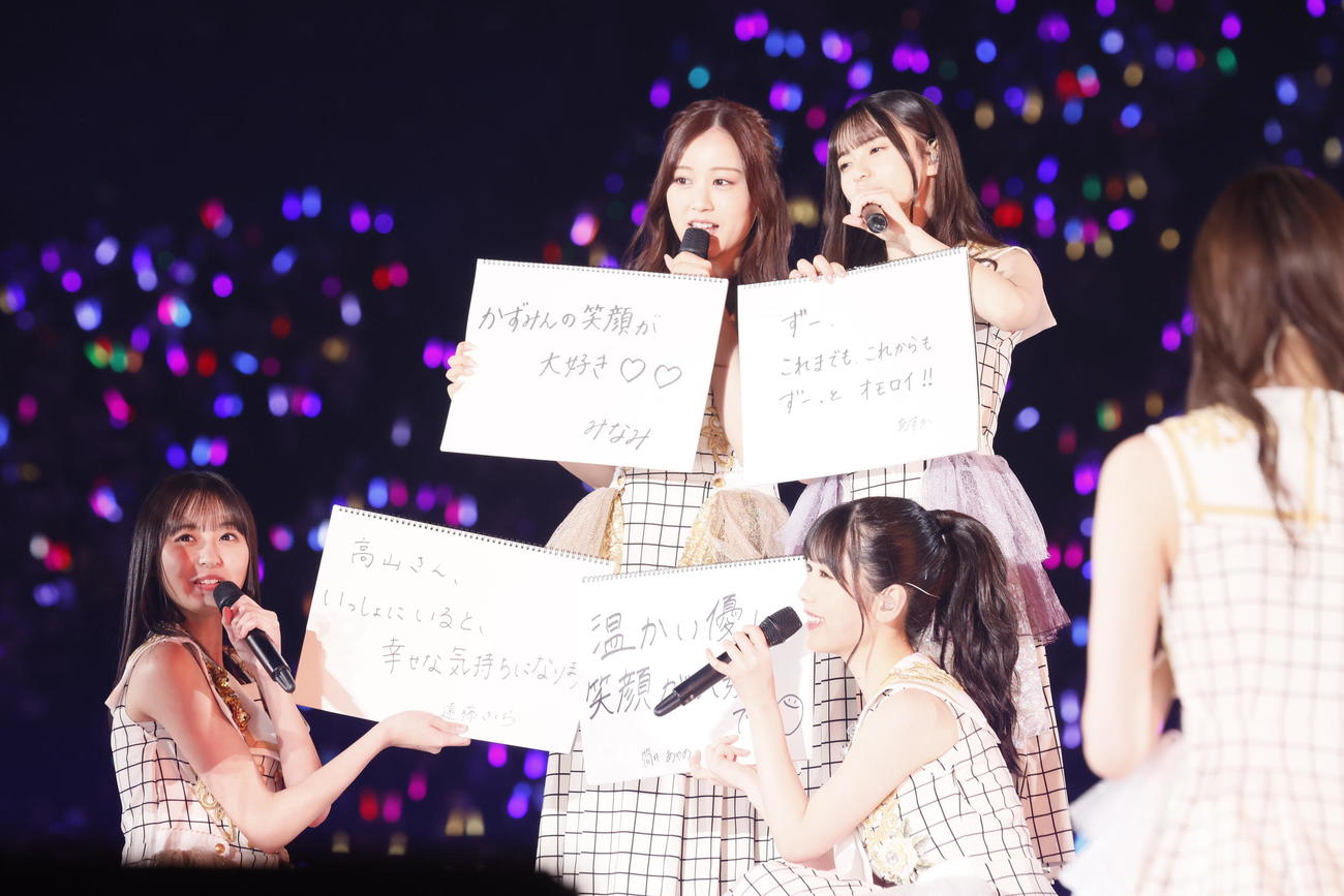 乃木坂46の「真夏の全国ツアーFINAL！」で、高山一実へのメッセージを見せるメンバー。前列左から遠藤さくら、筒井あやめ。後列左から星野みなみ、齋藤飛鳥