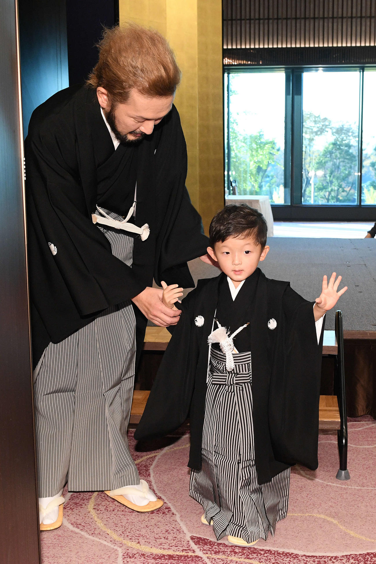 記者会見を終え、手を振りながら会場を後にする小川陽喜くん（右）と中村獅童（撮影・滝沢徹郎）