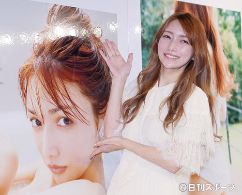 写真集出版記念フォトセッション＆トークショーで自身の写真の横でポーズをとる後藤真希（撮影・菅敏）