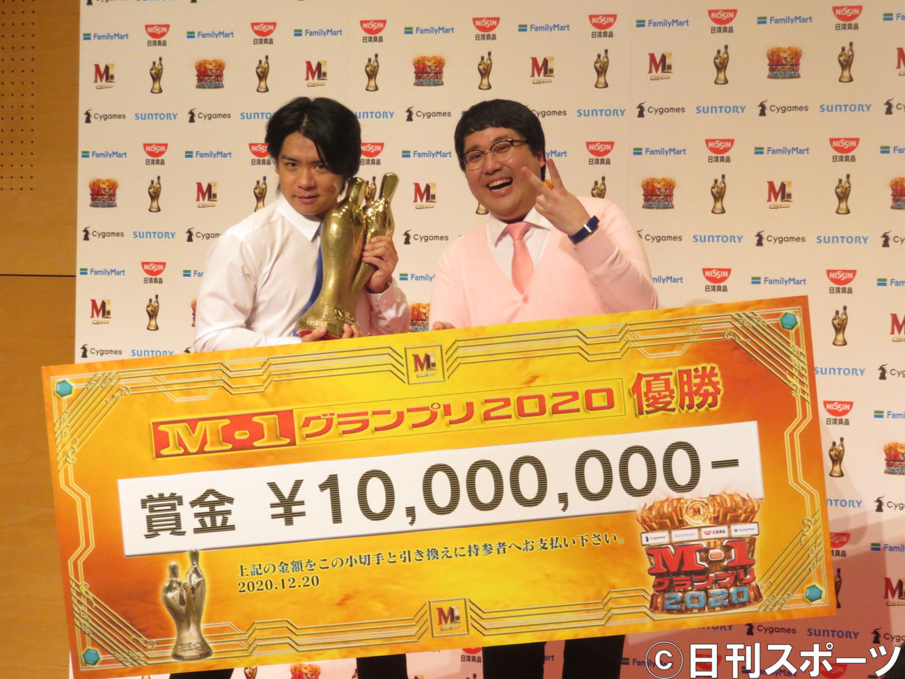 「M－1グランプリ2020」で優勝し、賞金ボードを手に笑顔のマヂカルラブリー野田クリスタル（左）と村上（20年12月撮影）