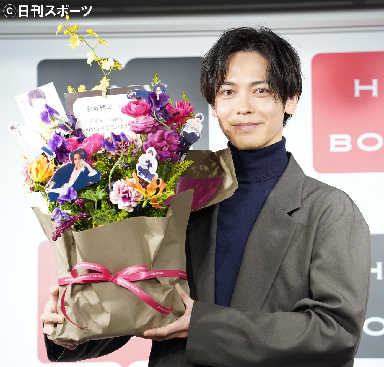 初のパーソナルブック「Special Thanks」の取材会で、花束をプレゼントされた猪塚健太（撮影・佐藤勝亮）