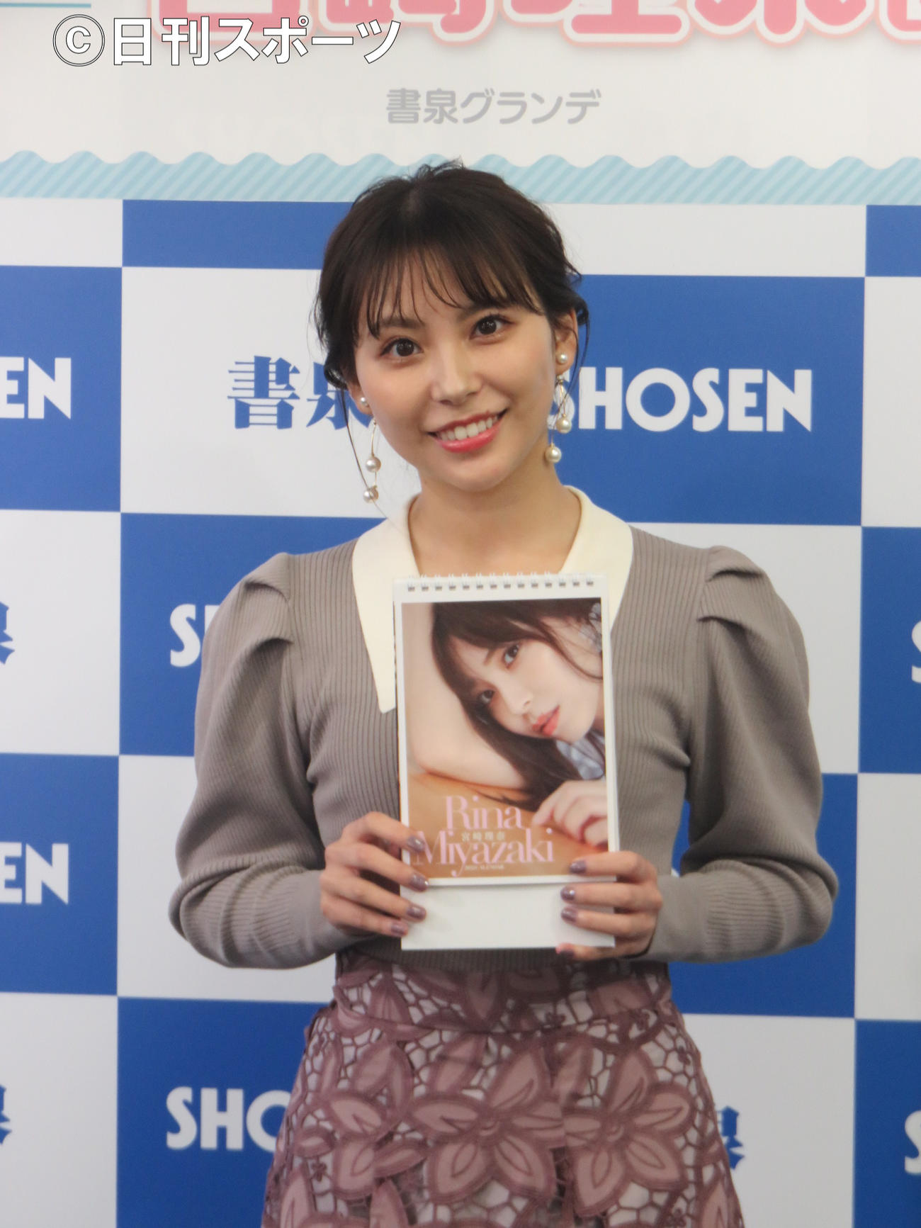 自身の来年の卓上カレンダーを手にする宮崎理奈