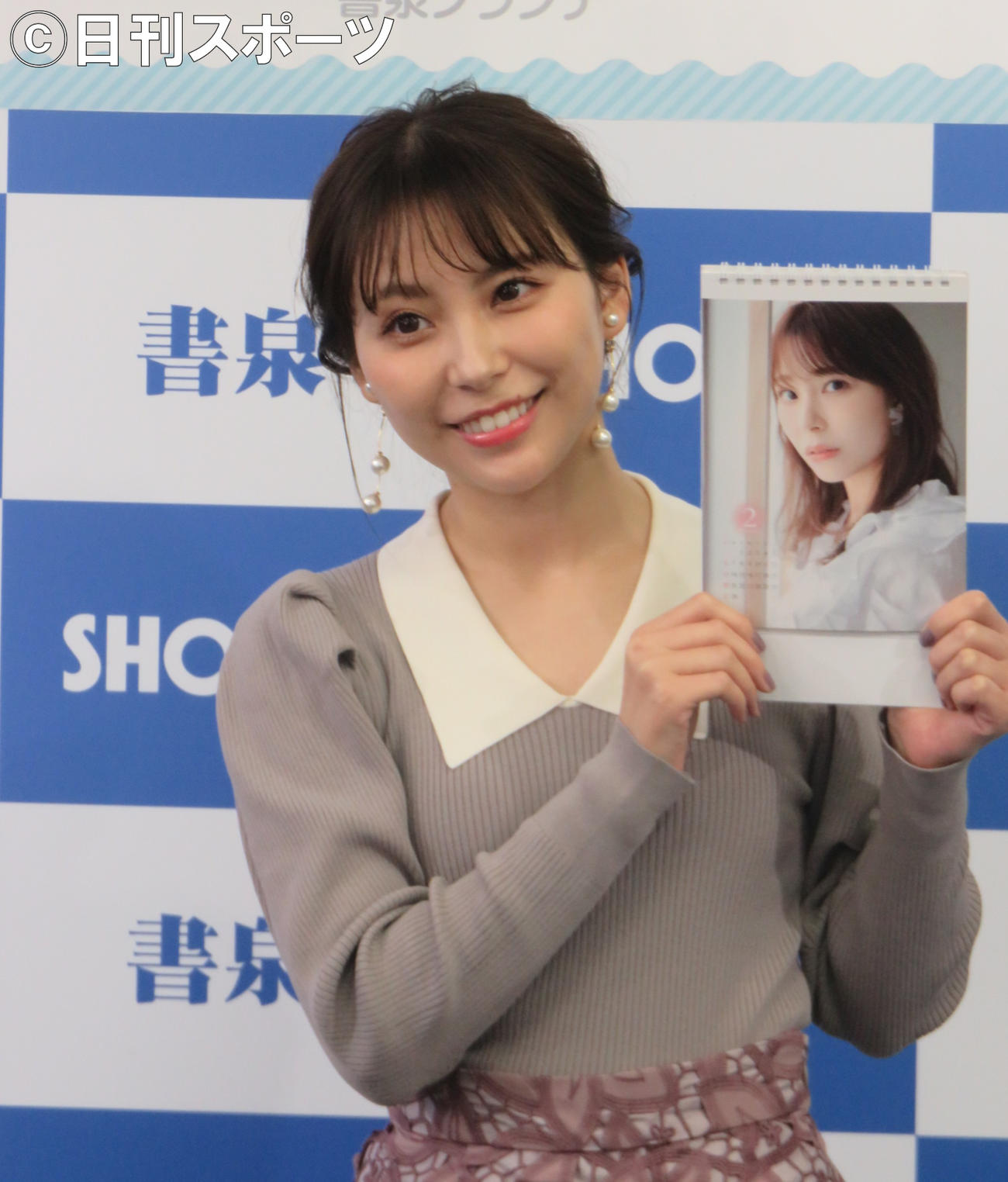 自身の来年の卓上カレンダーを手にする宮崎理奈