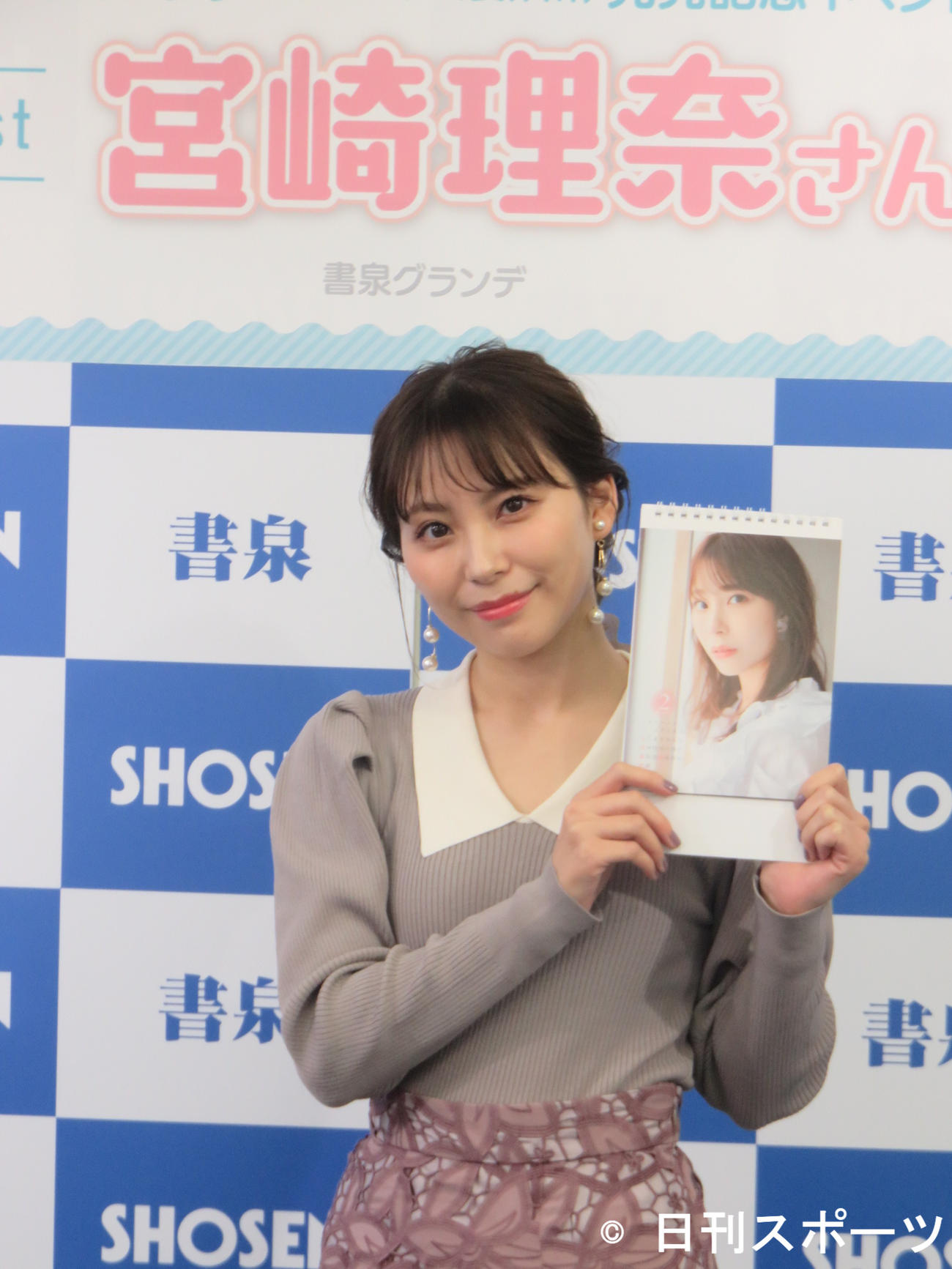 来年の卓上カレンダーを手にする宮崎理奈