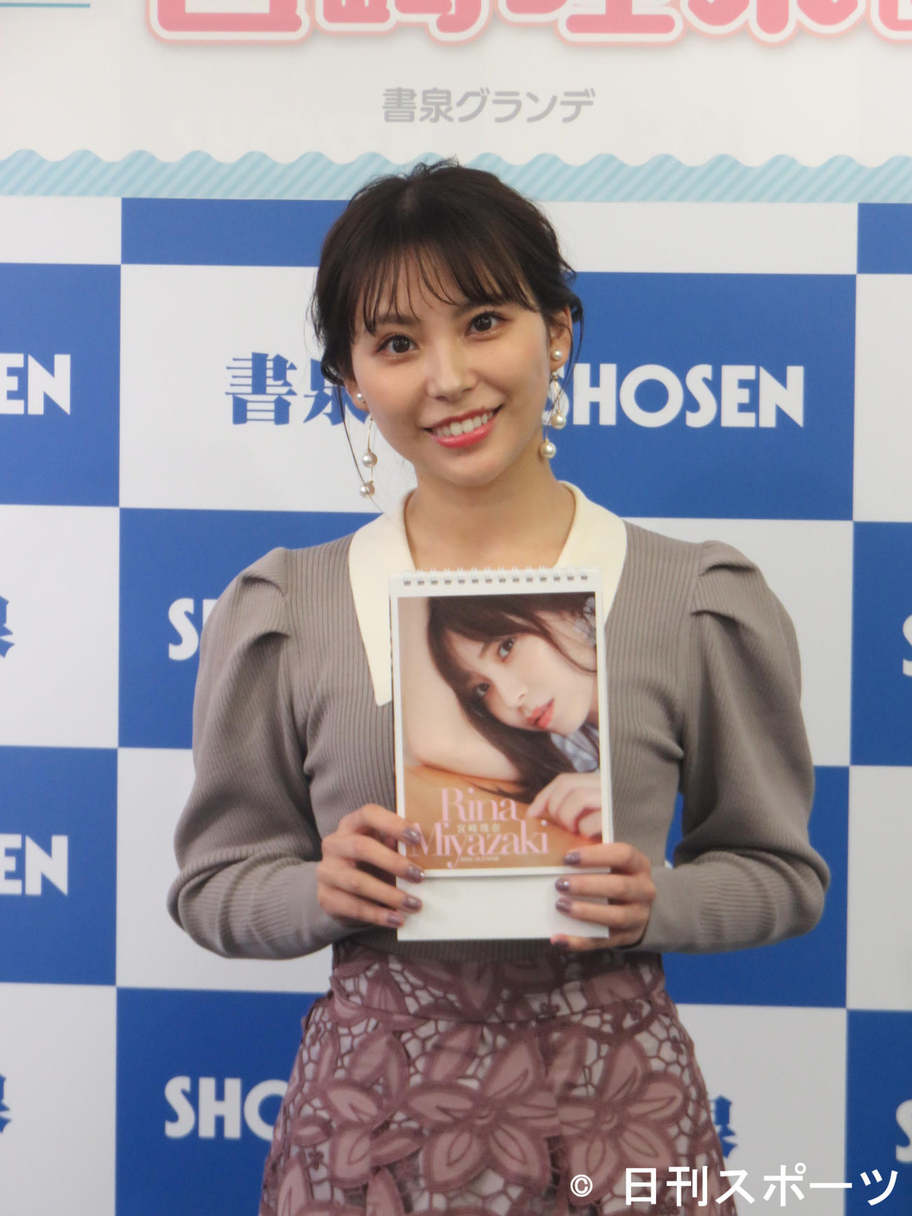 自身の来年の卓上カレンダーを手にする宮崎理奈