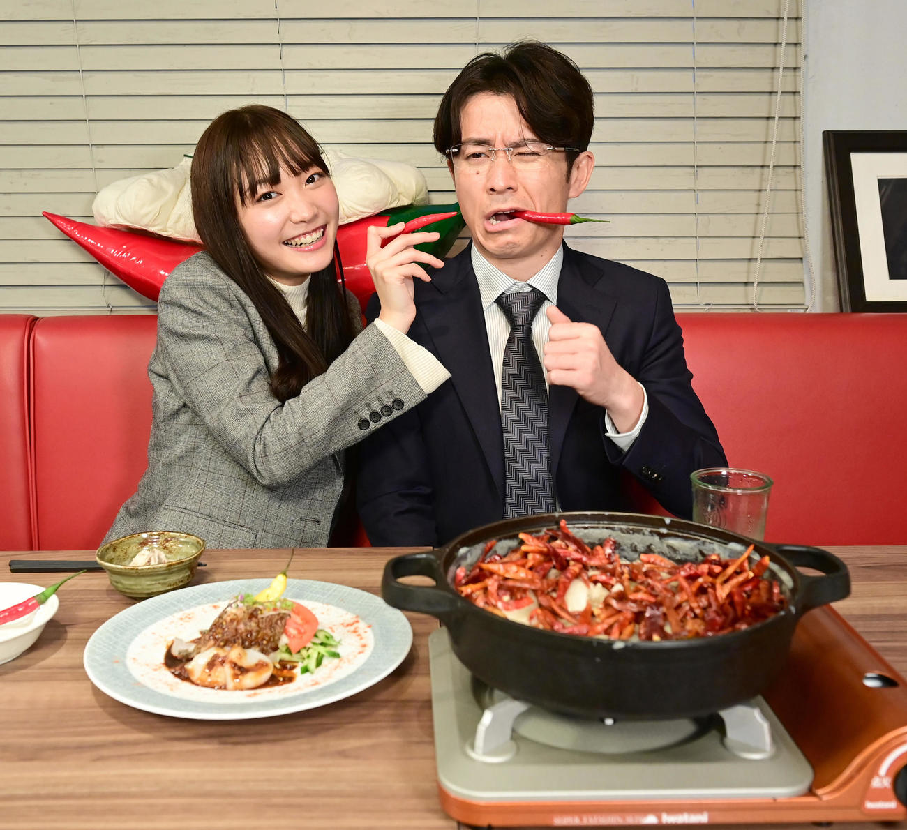 BS朝日「激辛課長」の収録に臨み赤とうがらしをかじって見せる藤森慎吾（右）と雪見みと（2021年12月撮影）