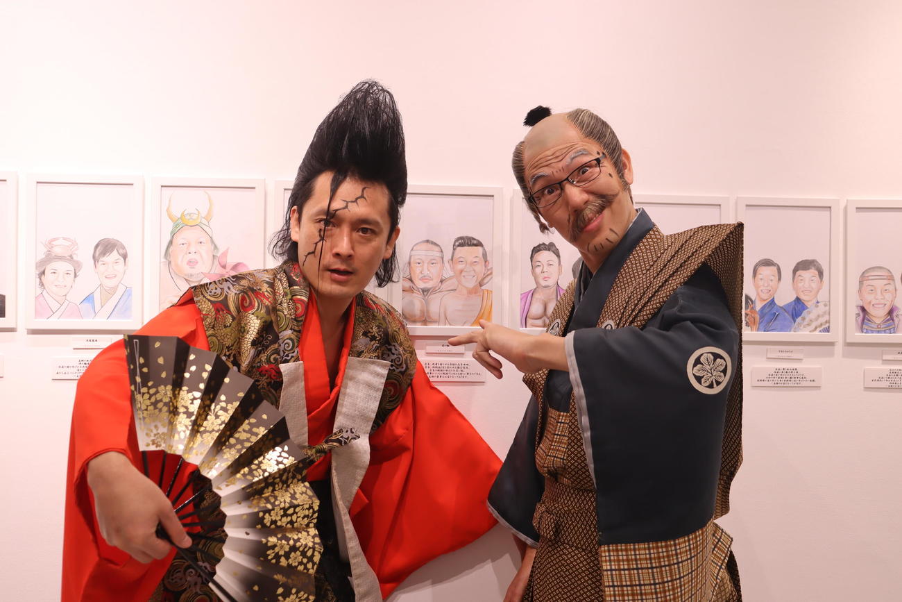 個展を開いた「武将様」ことミサイルマン岩部（左）と、ゴエ爺にふんした浅越ゴエ