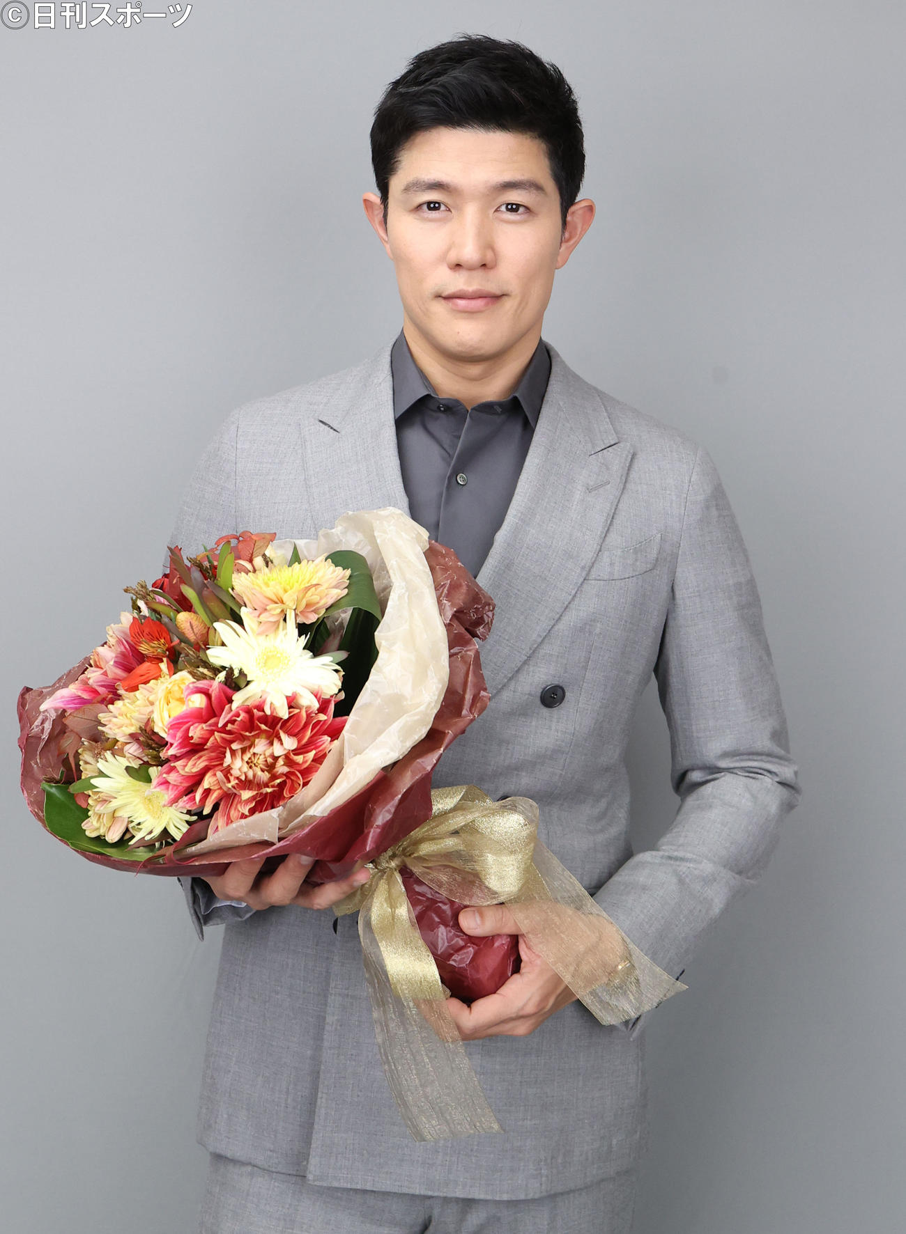 助演男優賞を受賞し花束を手に記念撮影に臨む鈴木亮平（撮影・狩俣裕三）