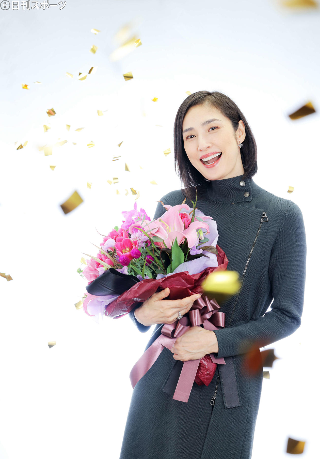 主演女優賞を受賞し、降り注ぐ金のペーパーシャワーの中で花束を手に笑顔で写真に納まる天海祐希（撮影・河田真司）