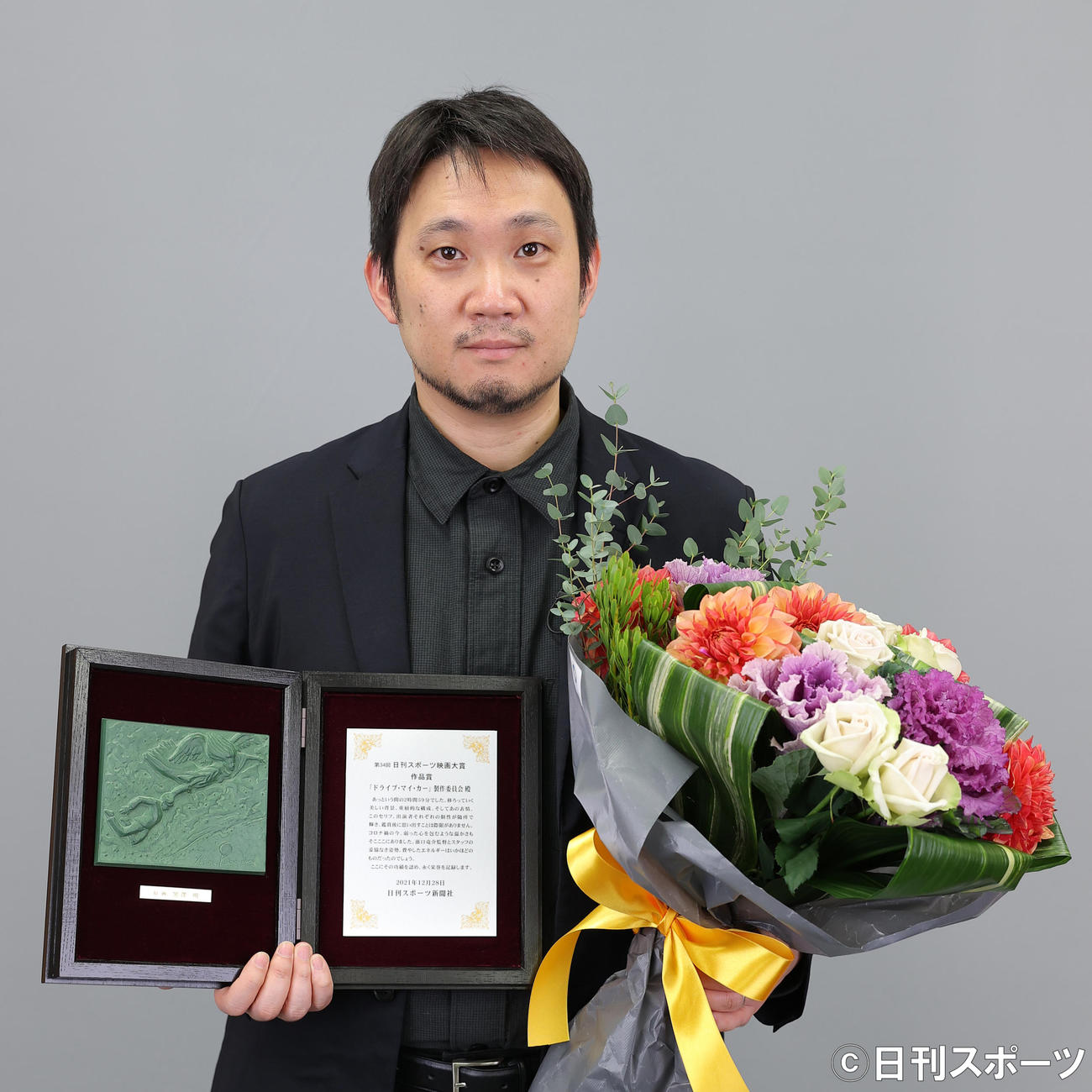 作品賞を受賞した濱口竜介監督は盾と花束を手にする（撮影・河野匠）