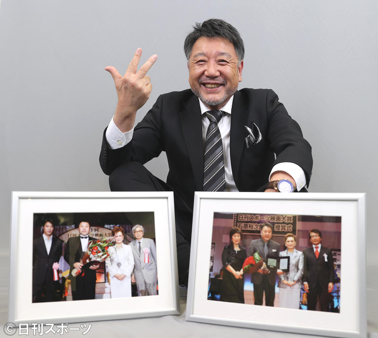 3度目の石原裕次郎賞を受賞し過去2回の授賞式の写真を前に笑顔を見せる原田眞人監督