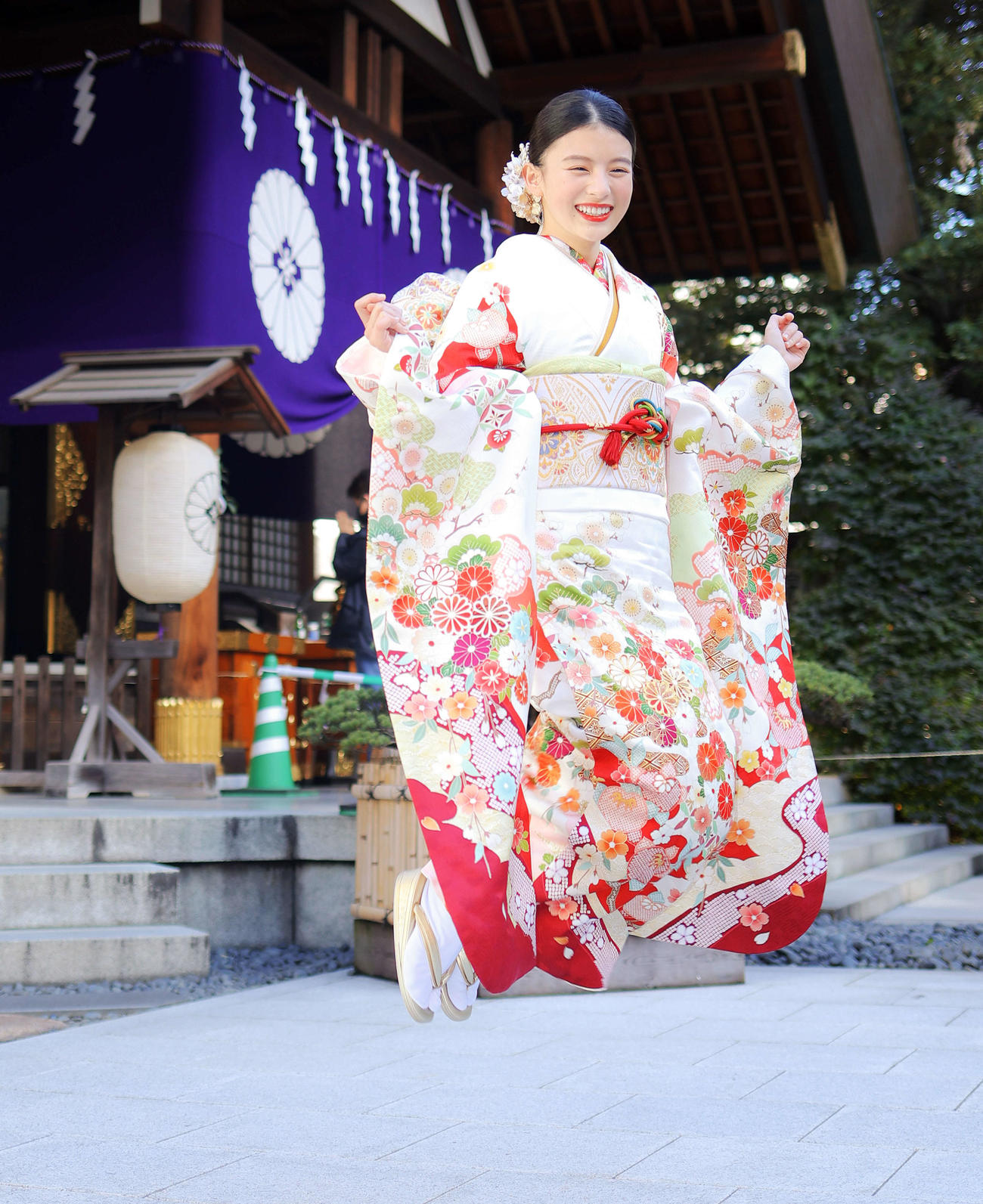 成人を迎え、晴れ着姿でジャンプする出口夏希（撮影・河田真司）