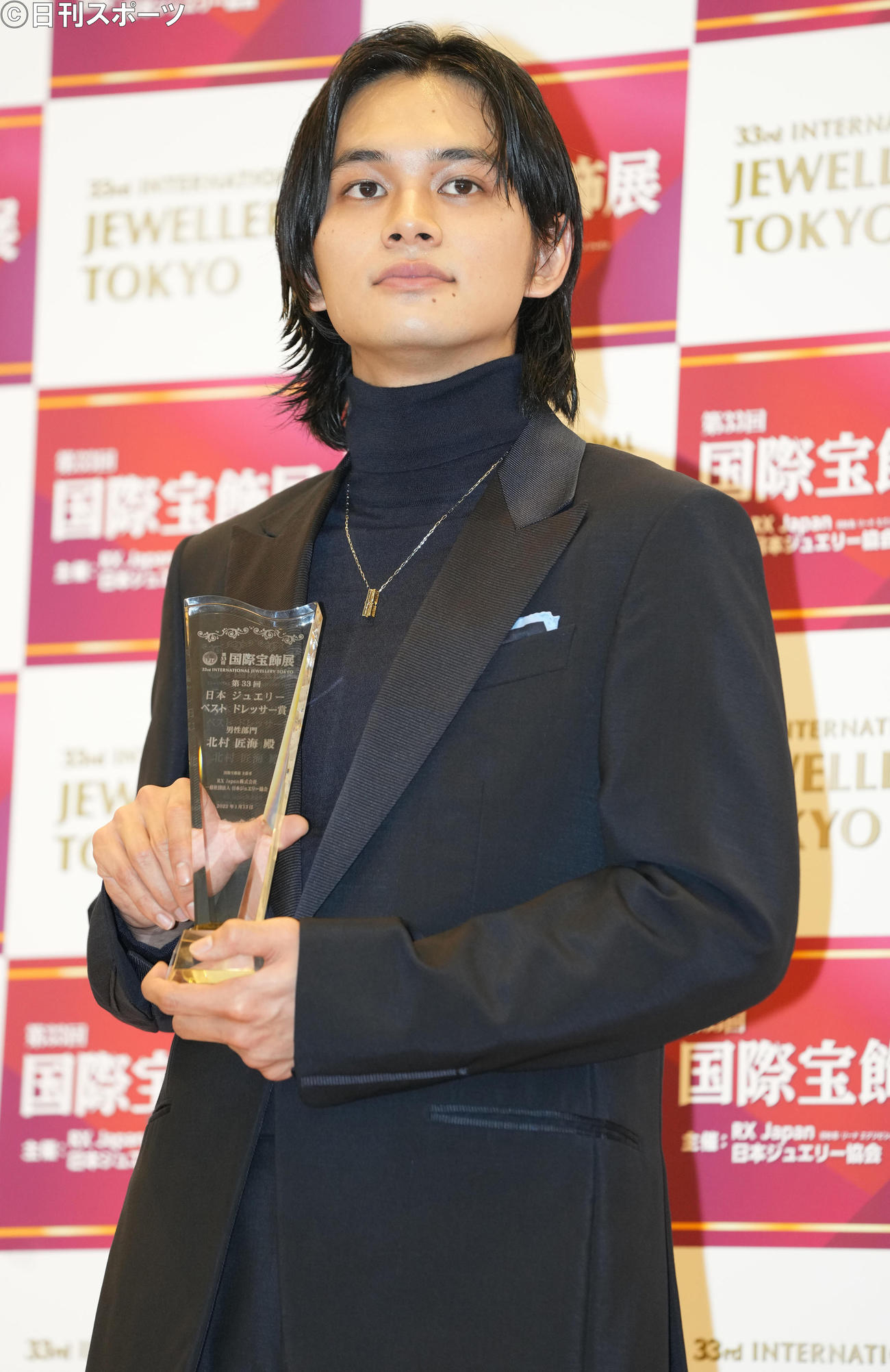 「第33回日本ジュエリーベストドレッサー賞」男性部門を受賞した北村匠海はトロフィーを手に写真に納まる（撮影・鈴木みどり）