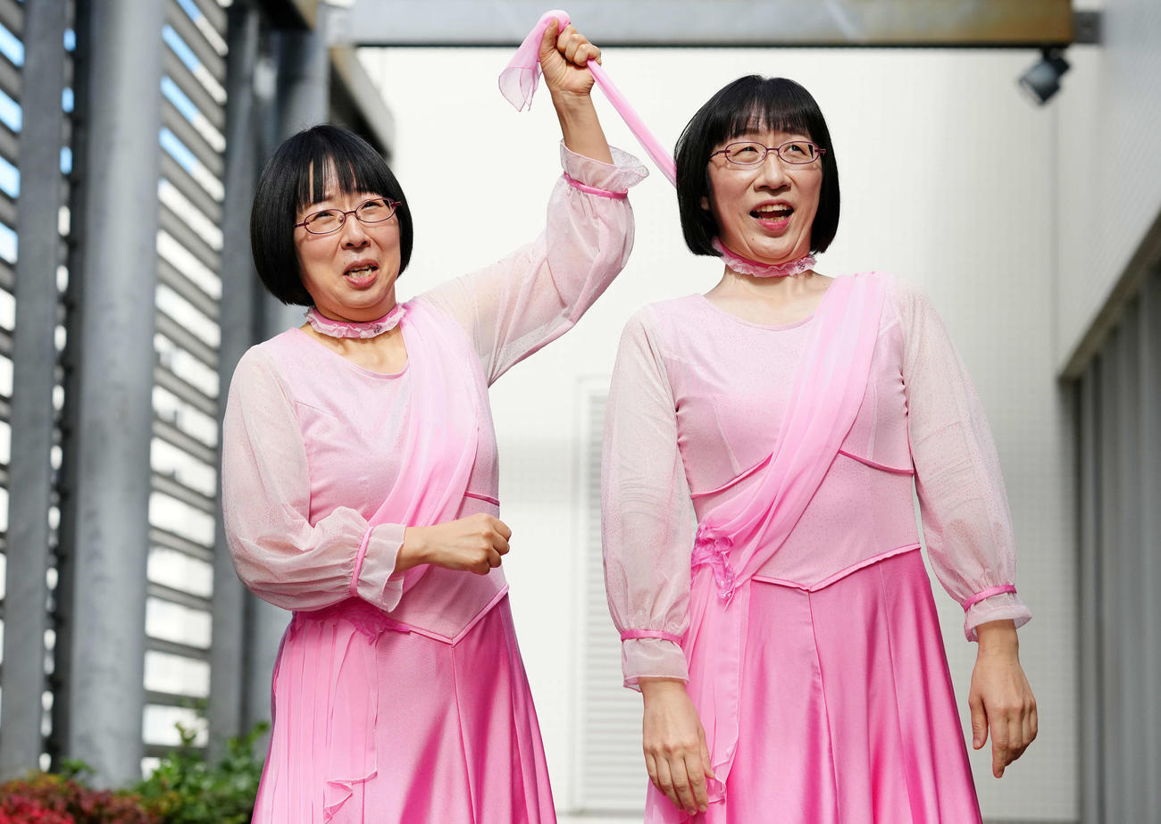 スカーフを締め上げるネタを披露するお笑いコンビの「阿佐ヶ谷姉妹」。右は姉の渡辺江里子、左は妹の木村美穂（撮影・江口和貴）