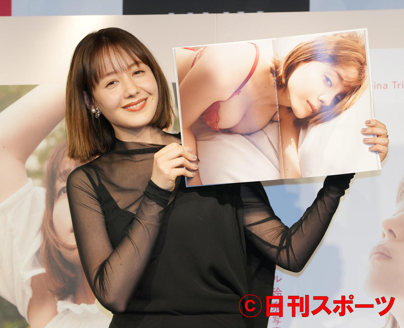 写真集「あいまい」発売記念イベントで、お気に入りのショットを広げ笑顔のトリンドル玲奈（撮影・鈴木みどり）