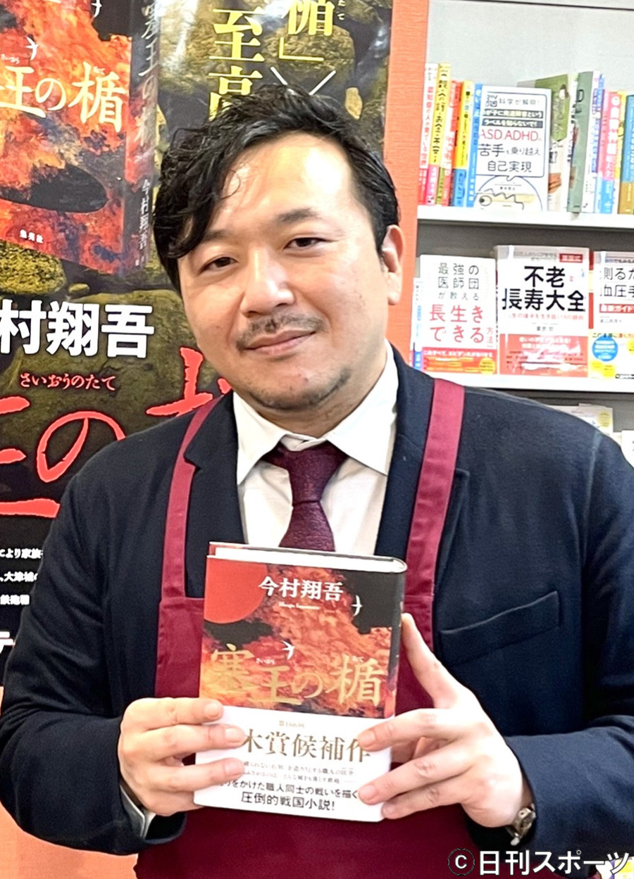 直木賞受賞作の「塞王の楯」を手にする、オーナーを務める「きのしたブックセンター」の一日店長を務めた今村翔吾さん