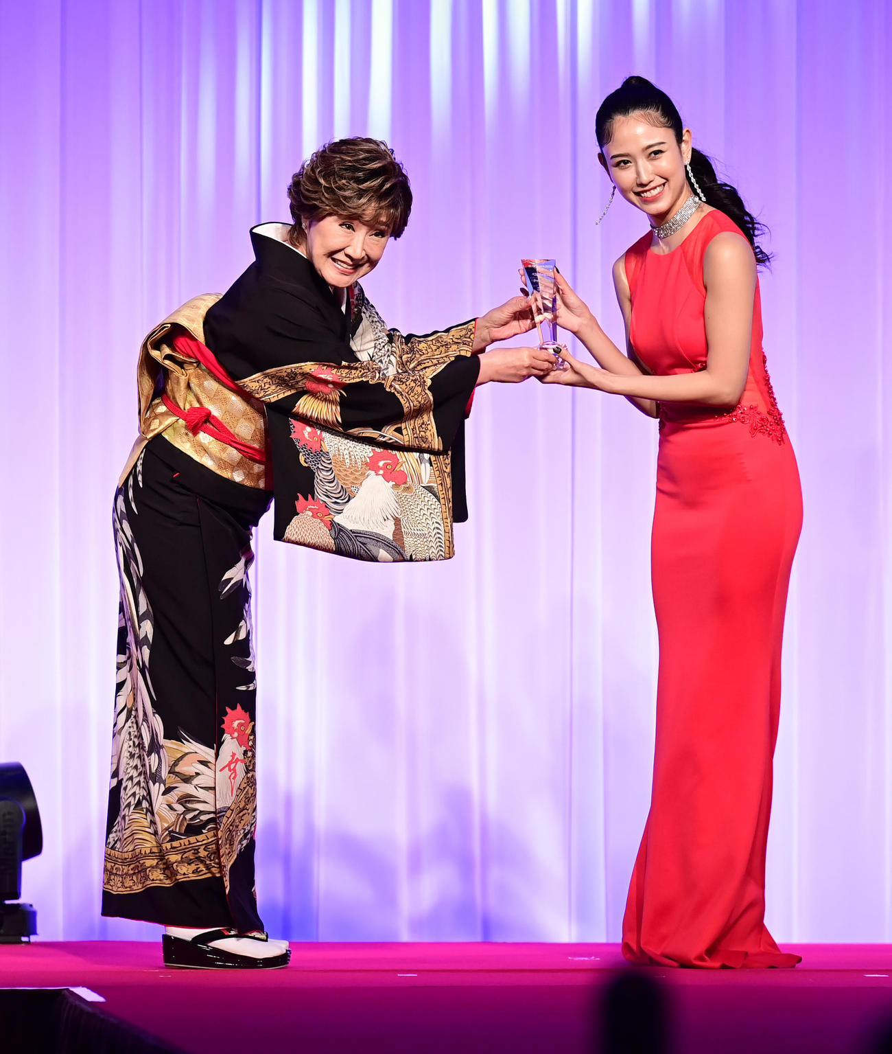 「K－1 AWARDS（アウォーズ）2021」でベストガールズ賞を受賞したチャナナ沙梨奈さん（右）にトロフィーを贈呈するプレゼンターの小林幸子（撮影・小沢裕）