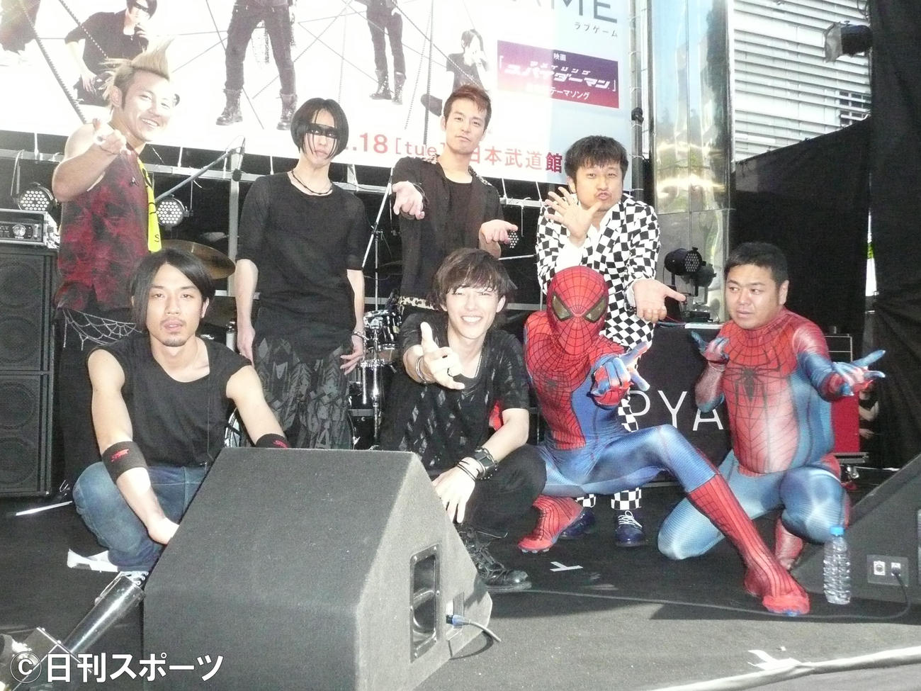 ゲリラライブを行った、前列左からUZ、IKE、ゲストのスパイダーマン、司会のダイノジ大地洋輔、後列左からENZEL、MOMIKEN、KENTA、ダイノジ大谷ノブ彦（2012年6月撮影）