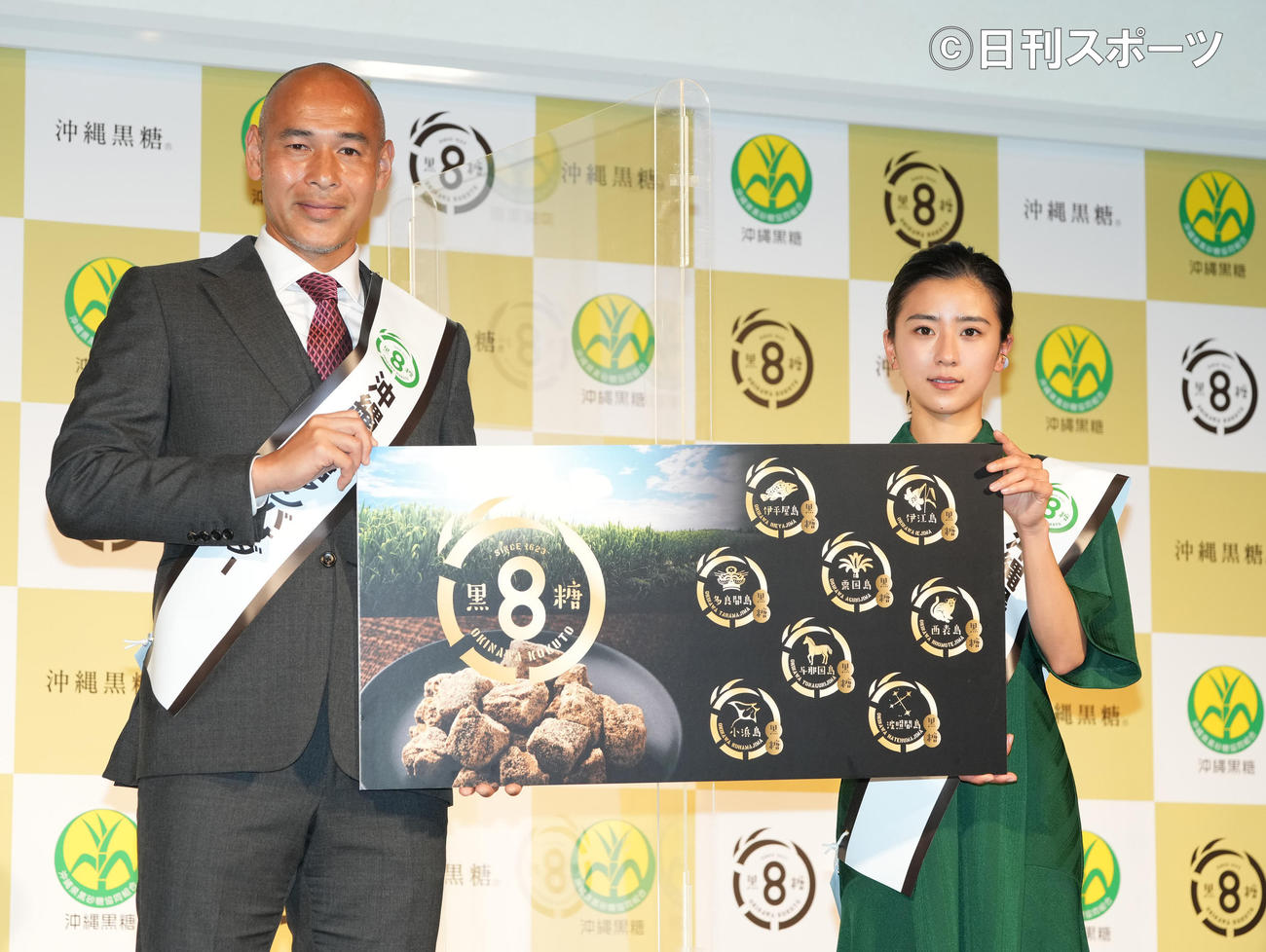 「沖縄黒糖アンバサダー」就任イベントでパネルを持ち笑顔の黒島結菜（右）と沖縄SVの高原監督（撮影・鈴木みどり）