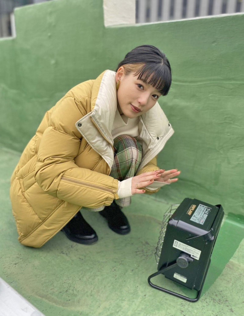 ちっちゃく縮こまって暖をとる石井杏奈（「ゴシップ #彼女が知りたい本当の○○」オフィシャルブログより）