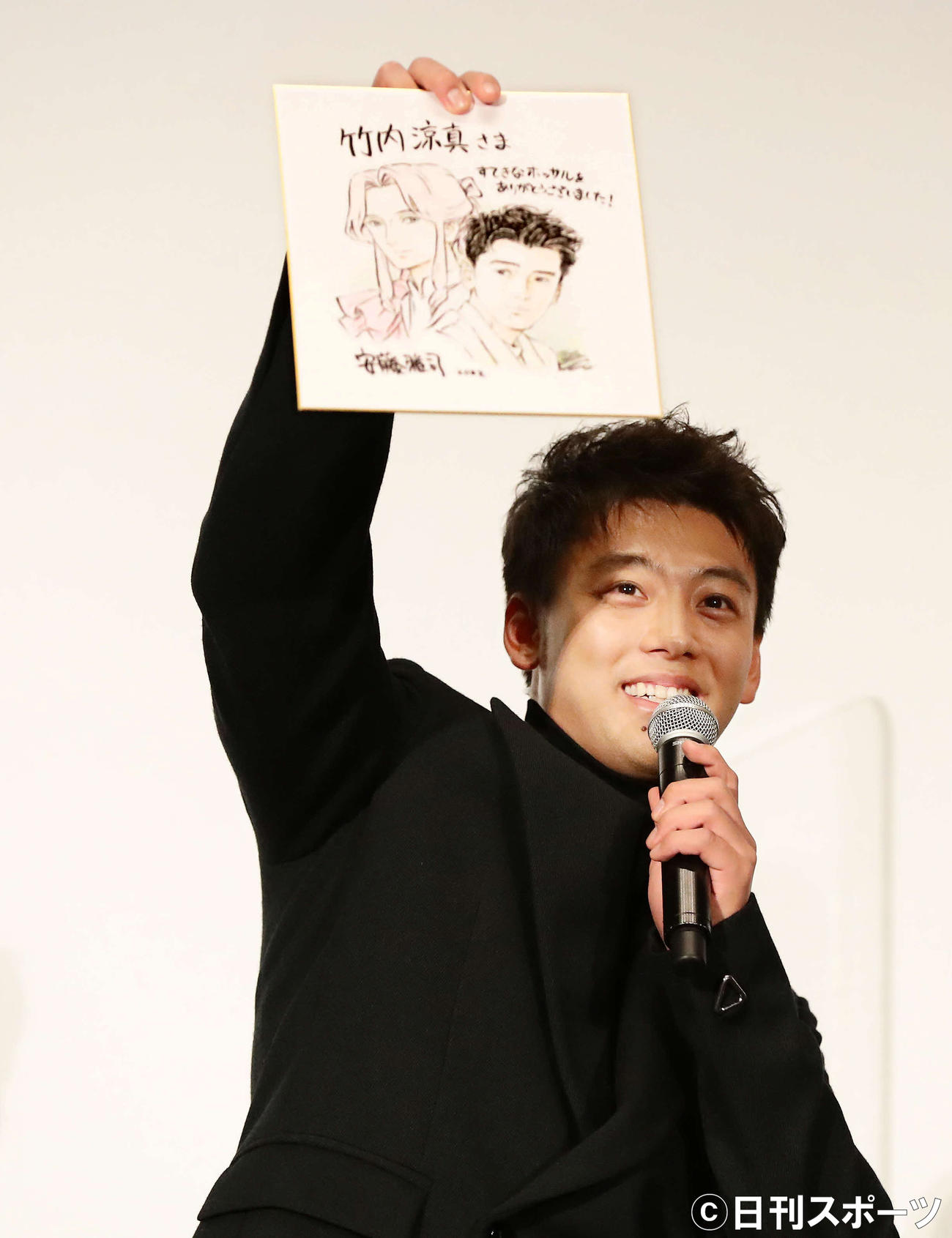安藤雅司監督からプレゼントされたイラストを掲げる竹内涼真（撮影・丹羽敏通）